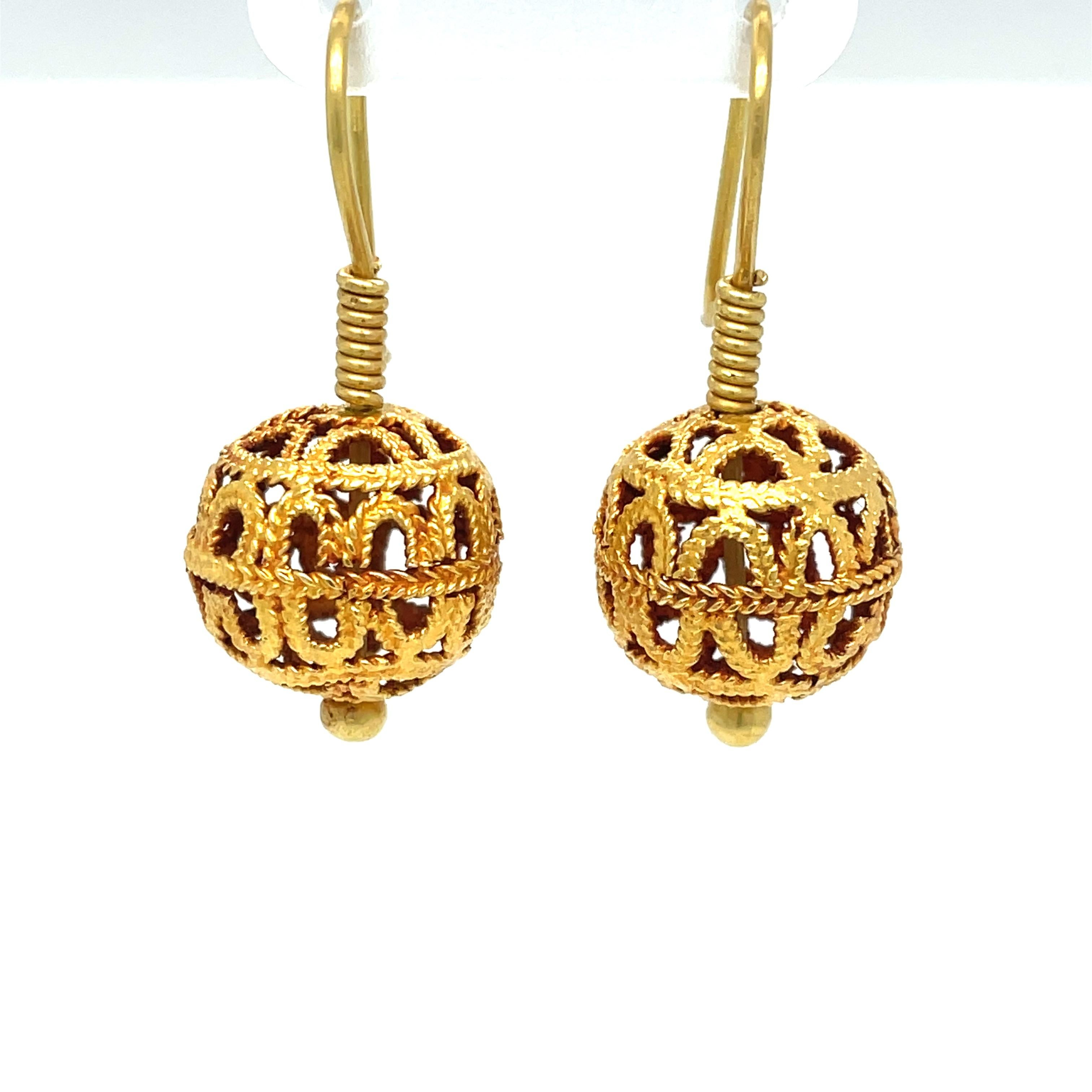 Pleasing 13.5mm spheres of textured 18 karat yellow gold create this versatile, go-to pair of artful drop gold earrings.
Hand assembled with a pleasing patina, the gold pair has an easy to apply fish hook closure. This classic round ball style