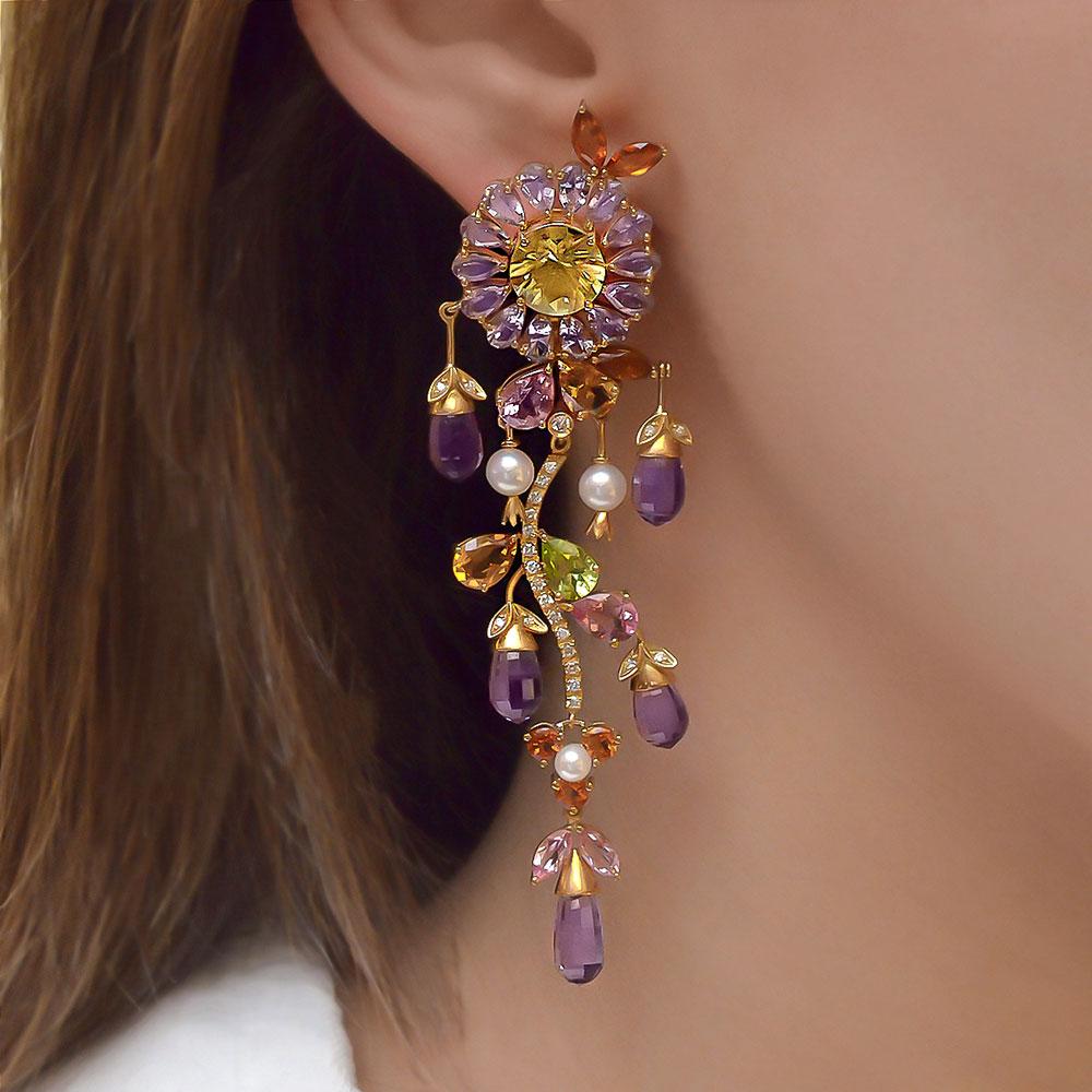 Set in 18 kt. yellow gold, are these stunning multi-color gem flower hanging earrings with round Scapolite centers surrounded by Pear shaped Amethysts. Cascading from the flowers are Briolettes of Amethyst.
 A diamond stem is then accented with pear