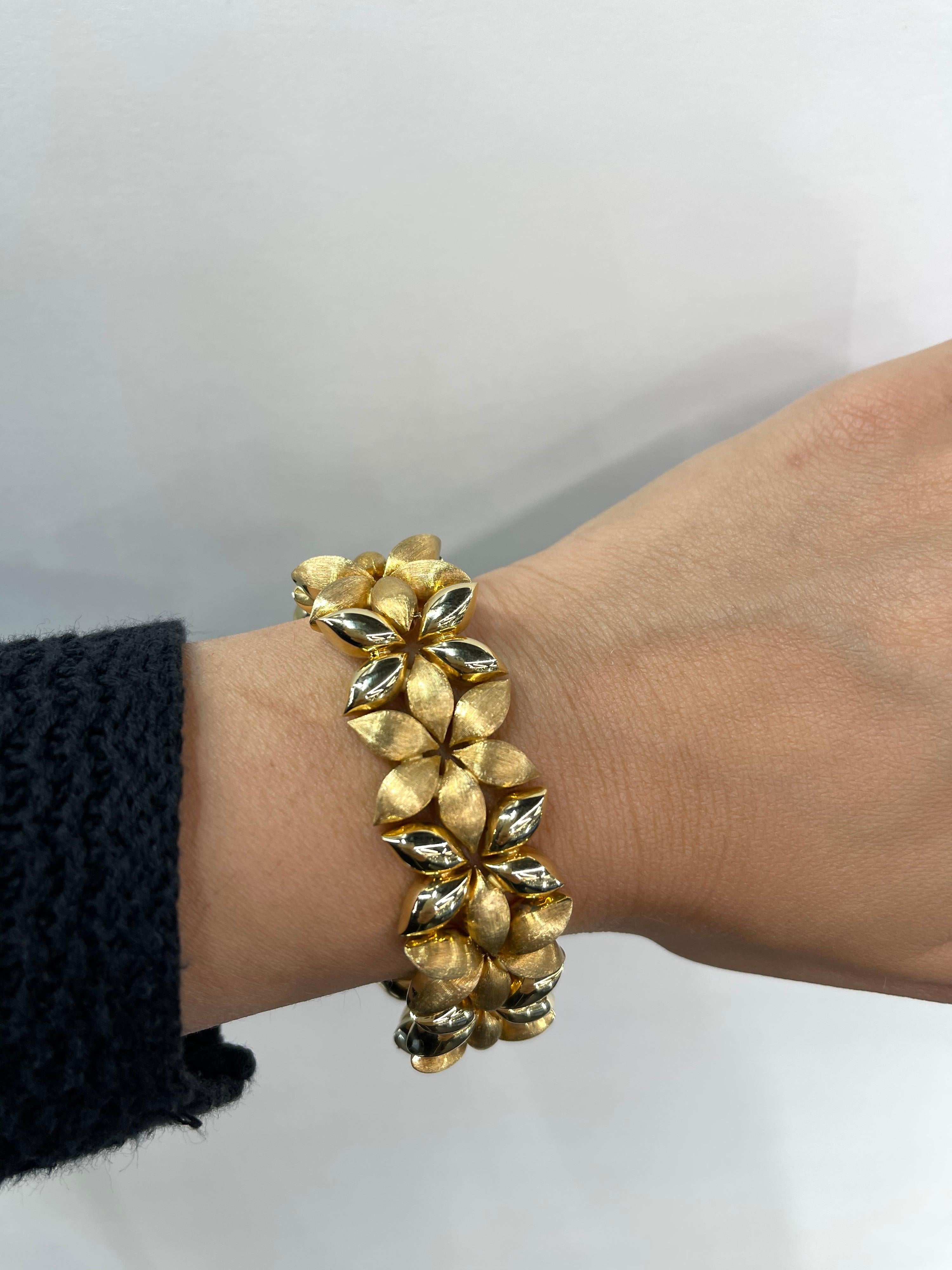 18 Karat Yellow Gold wide bracelet featuring 14 floral brushed & high polish finished weighing 51.2 grams. 
Nice & Bold bracelet. 