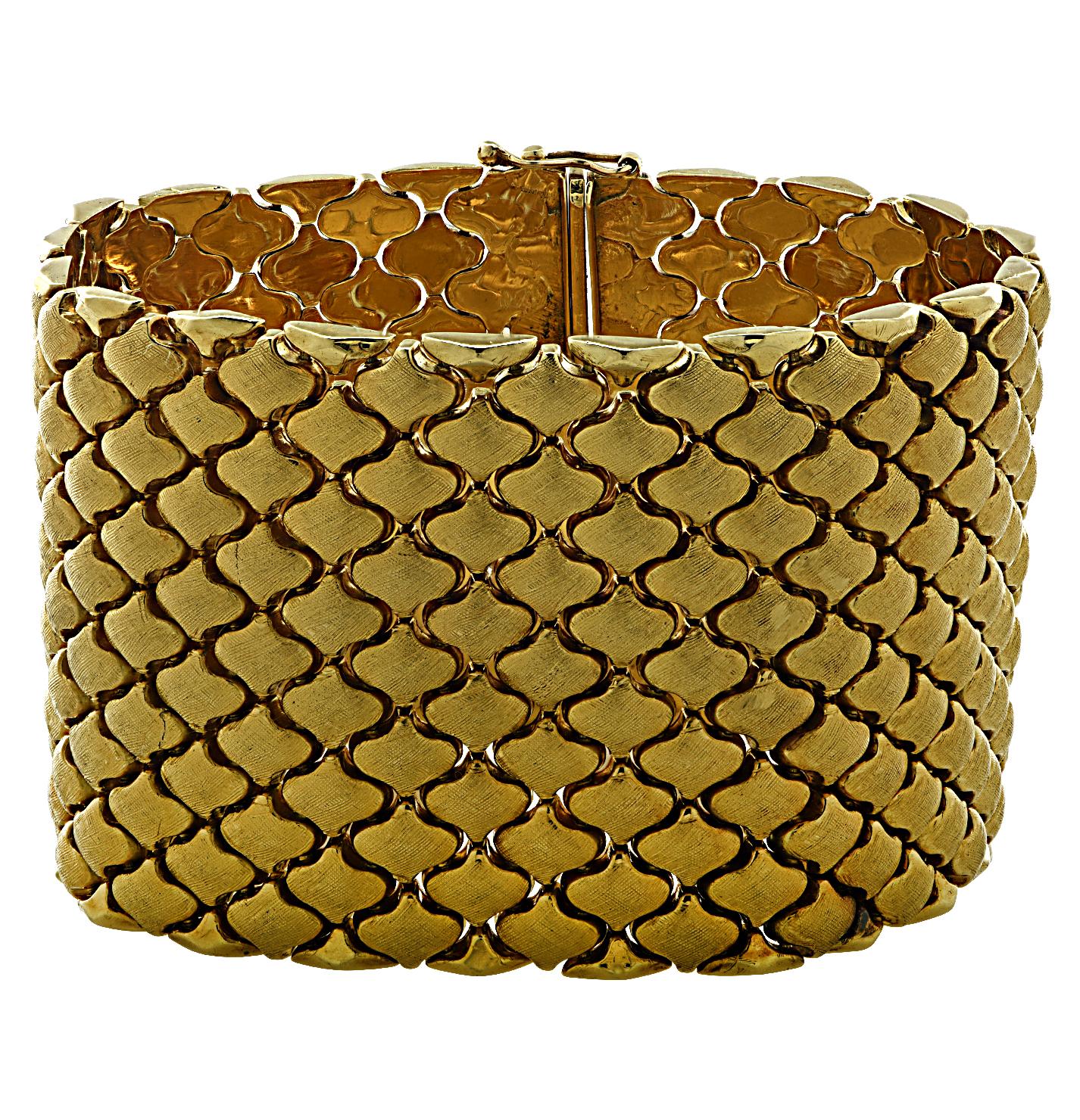 Stunning bracelet crafted in 18 karat yellow gold. Florentine finished links interlock to create a striking design. This gorgeous bracelet measures 7.5 inches in length and 1.8 inches in Width. It weighs 108.5 grams and closes with a hidden box