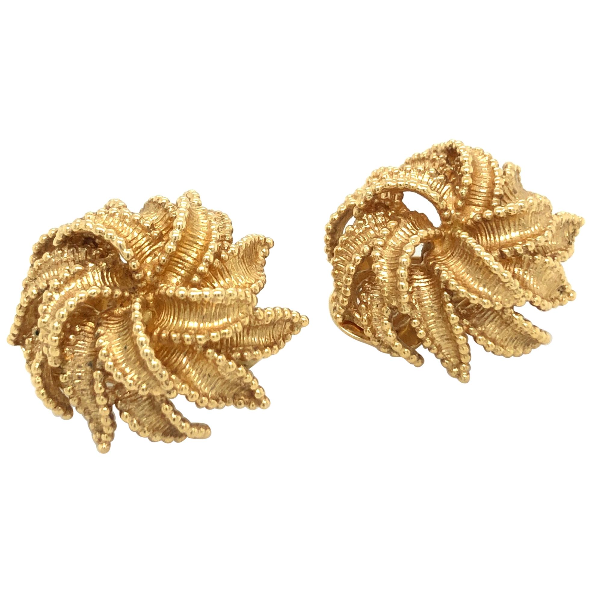 Ravishing pair of 18 karat yellow gold flower ear clips by long-established Swiss jeweler Bucherer. 
These beautifully handcrafted mid-century ear clips are designed as voluminous flowers in which each petal is structured and carefully bordered by