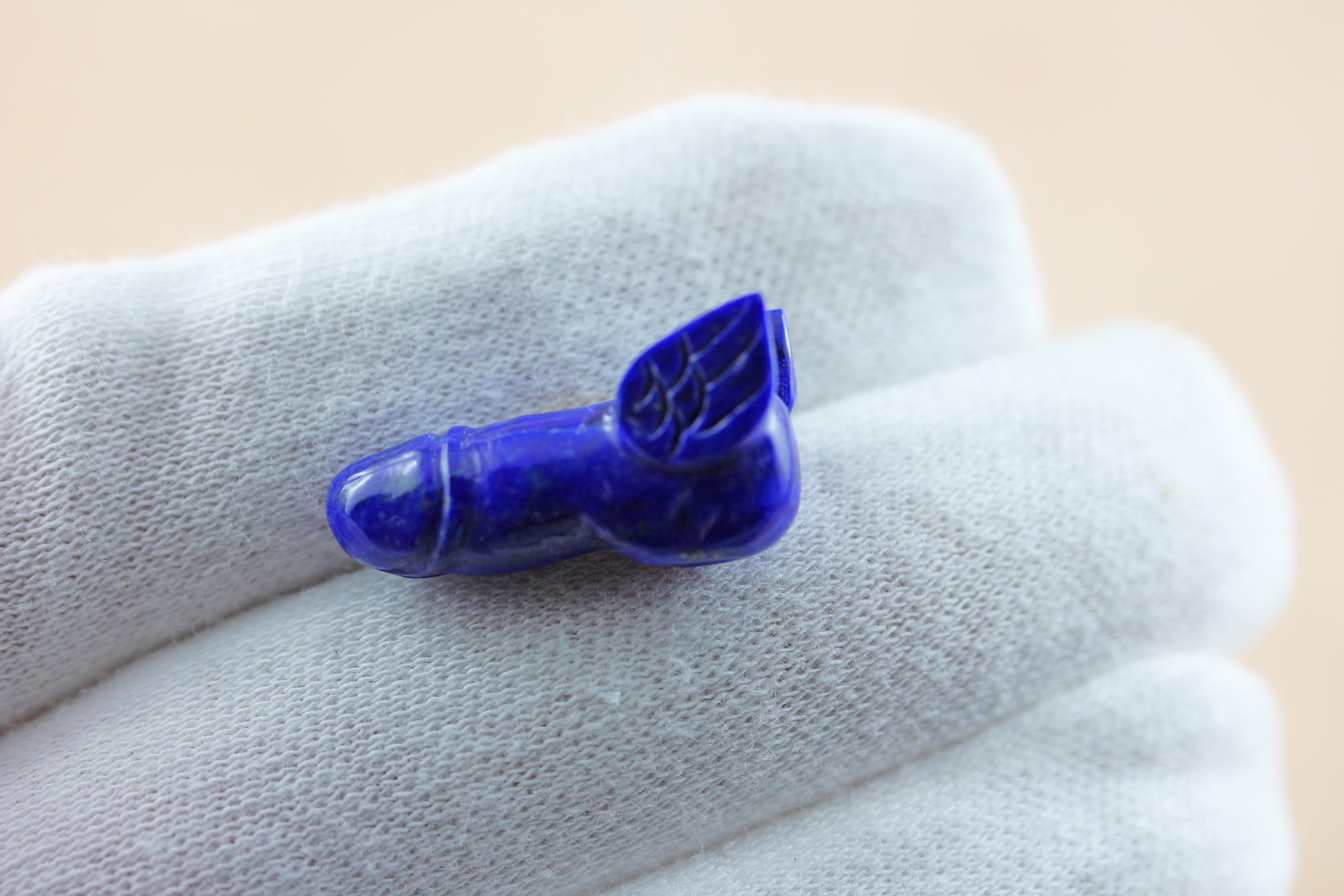 Cette paire de boutons de manchette ludique est entièrement réalisée en lapis-lazuli. 
L'anneau est un simple hexagone allongé avec une tige en or jaune 18k, tandis que le protagoniste de la pièce a la forme d'un phallus accessoirisé de manière