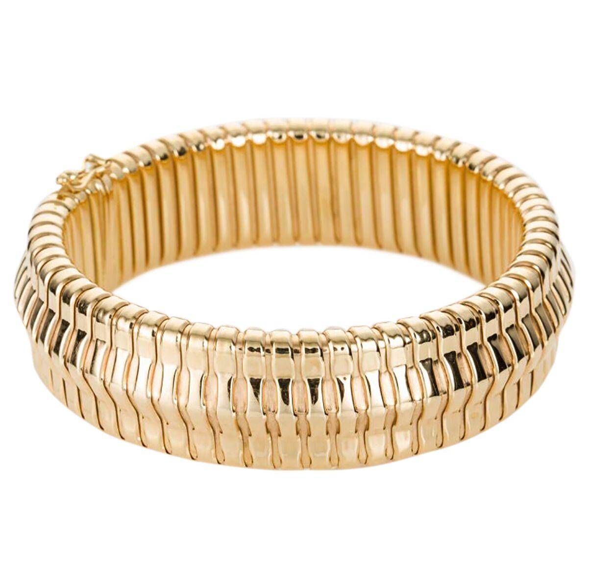 Sleek and stylish this 18k yellow gold gooseneck bracelet sits so comfortably on the wrist you don't even know you have it on. The perfect piece to layer with other bracelets but looks just as good on its own. Made from ribbed gold pieces that work