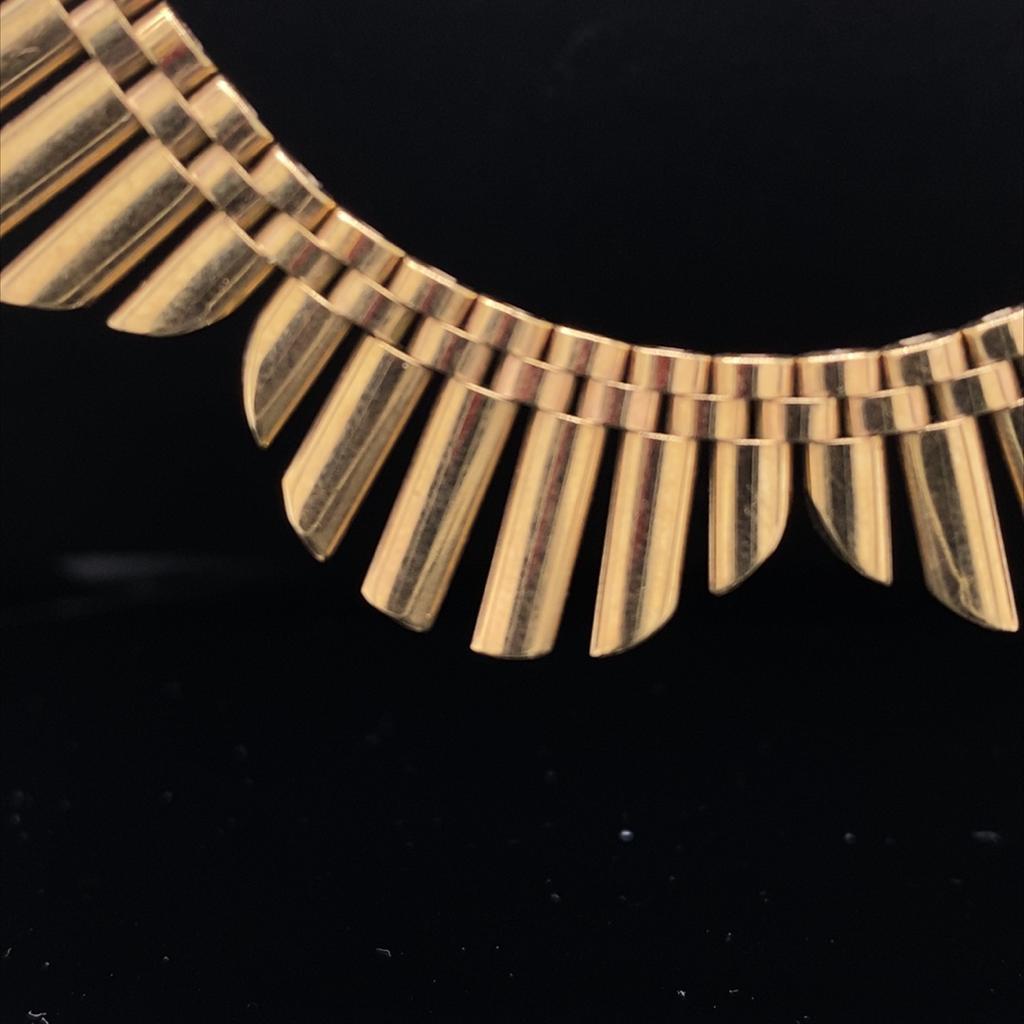 A striking vintage gold fringe collar in 9ct yellow gold, circa 1960.

The polished gold links of this collar are beautifully articulated and the piece sits flat on the collar bone of the wearer meaning that it can easily be worn with V-neck and