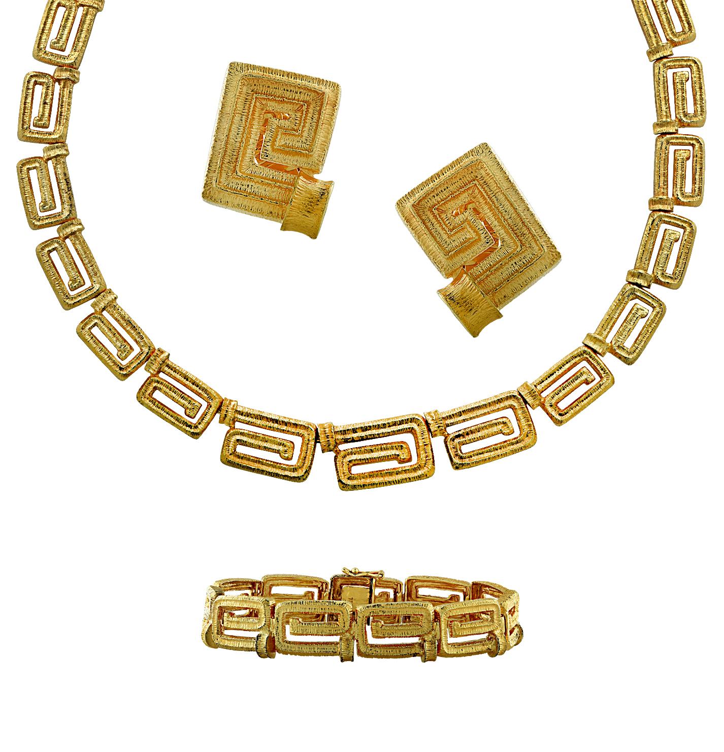 Stunning Greek Key jewelry suite featuring a necklace, bracelet and earrings crafted in 18 karat yellow gold. The necklace measures 17 inches in length and 11.8 mm in width. It closes with a hidden box clasp and safety lever. The bracelet measures