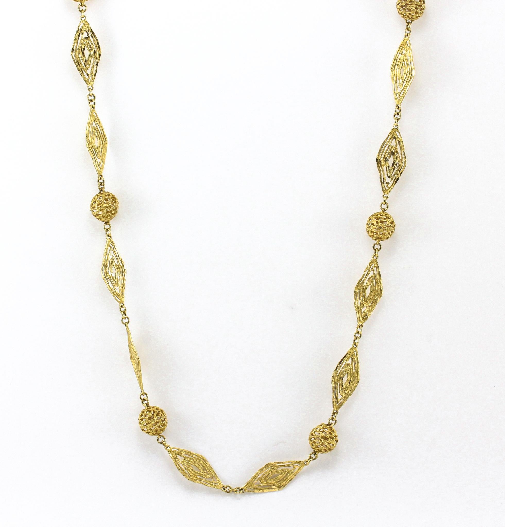 This 18 Karat Yellow Gold 34.25 inch long Necklace, fabricated in a Greek Motif Style is sure to make a fashion statement. A stunning necklace with reticulated spheres and leaf-shaped open hammered links for an artistic interpretation of ancient