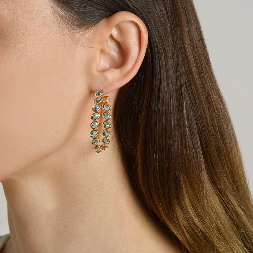 18kt yellow gold Ombré hoop earrings with bezel set multishade oval green sapphires at 11 o'clock® and signature Brillante® motif, grande.

Reimagined from summers spent at the Tuscan shore, the Ombré collection highlights the diverse hues and
