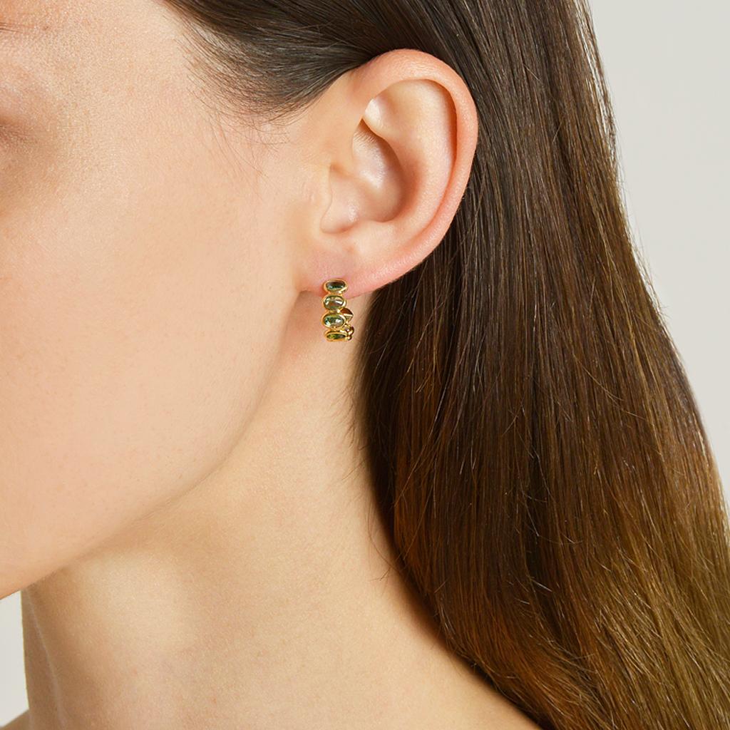 18kt yellow gold Ombré hoop earrings with bezel set multishade oval green sapphires and signature Brillante® motif, petite. 

Reimagined from summers spent at the Tuscan shore, the Ombré collection highlights the diverse hues and textures found in