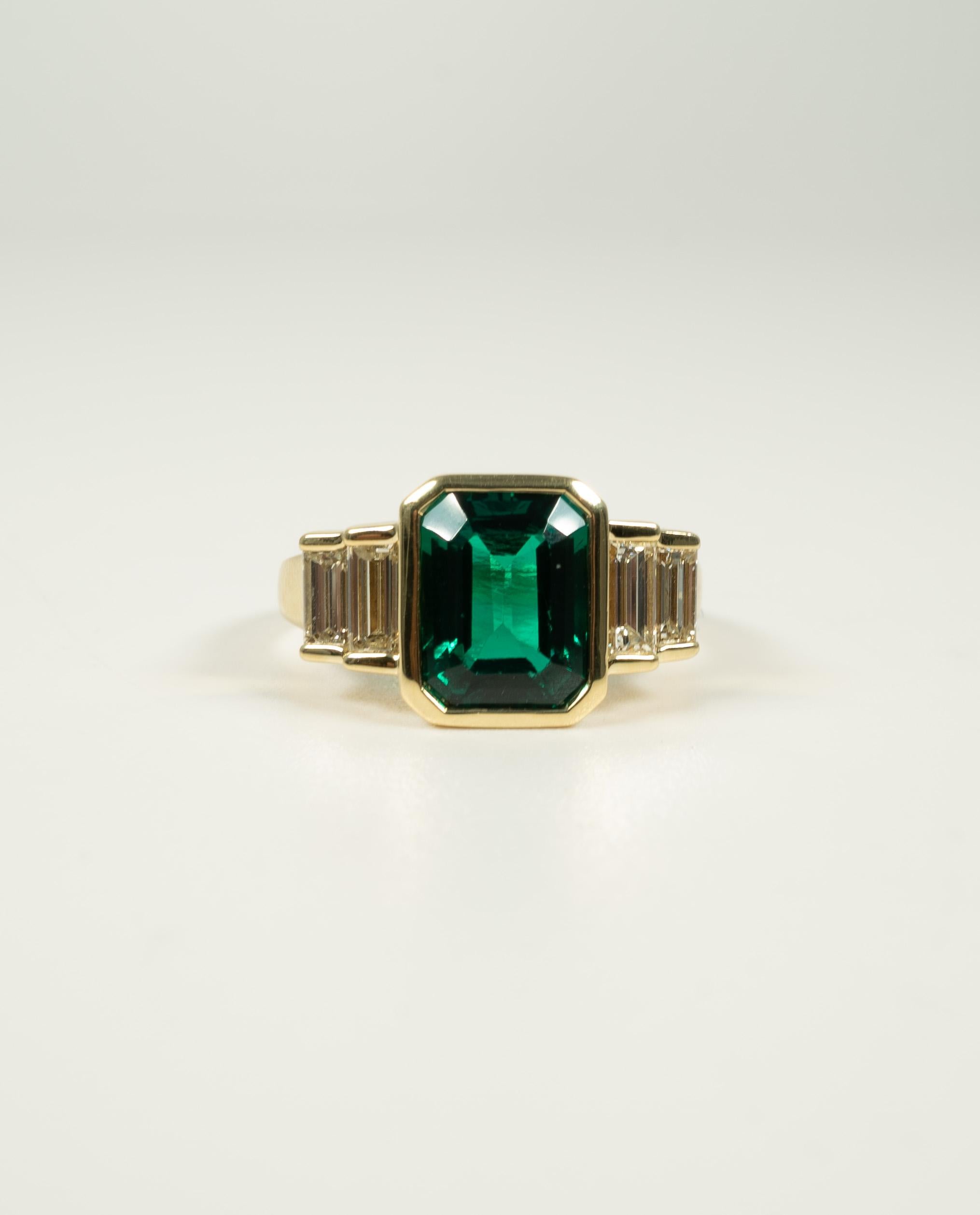 Un anello davvero stupendo!  Al centro una pietra verde a forma di rettangolo incastonata, affiancata da splendidi diamanti a baguette dritti con un peso totale stimato di 0,65 carati. 