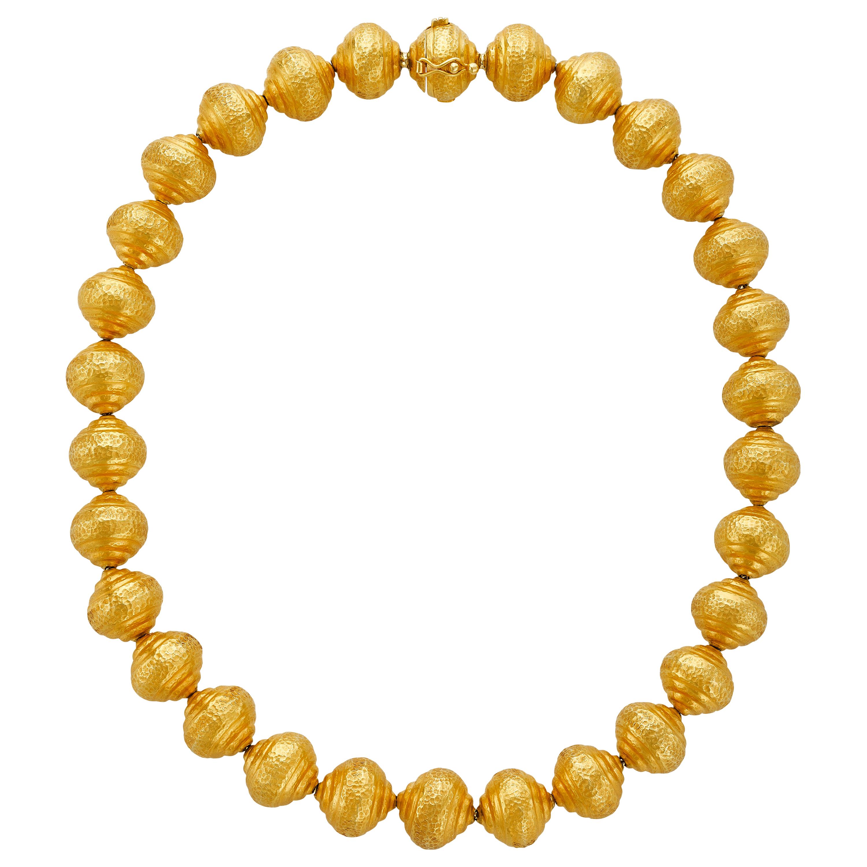 This unique necklace has charming 18k yellow gold hammered balls that are strung together and tapered on a 16” chain. The necklace has a hidden clasp and safety and sits perfectly on any woman’s neck. 