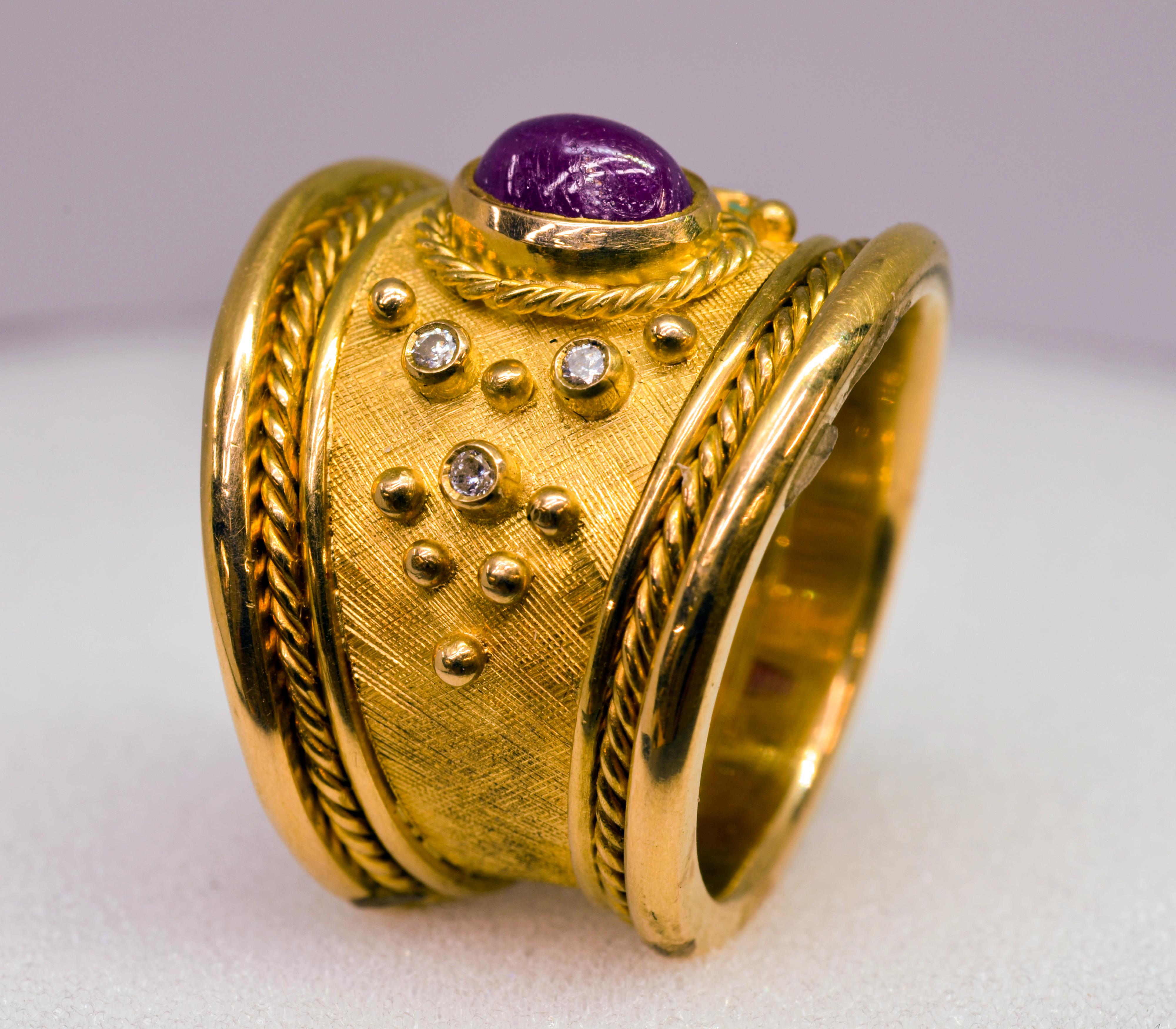 18 Karat Yellow Gold Handmade Diamond and Ruby Tapered Cigar Band Ring.
This bold ring is handcrafted in 18 Karat gold and is set with a Cabochon cut Ruby and six small round Diamonds. This style is sometimes called “Templar” or “Cigar Band”. It is