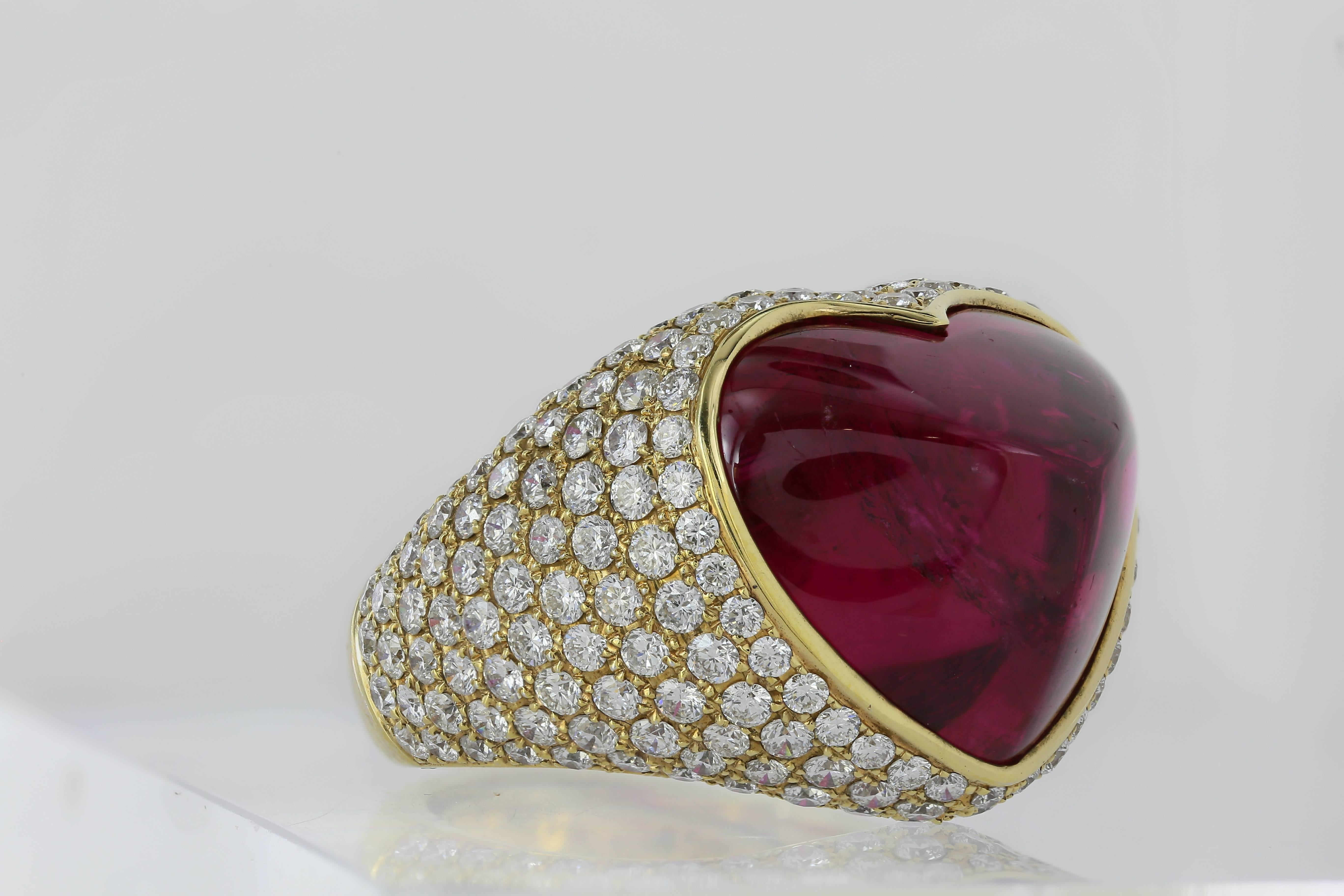 18 karat white gold with yellow gold plating tourmaline and diamond ring, featuring one reddish purple heart shaped sugarloaf tourmaline weighing 17.63 carats surrounded by pave diamonds weighing a total of 3.83 carats and openwork heart shaped
