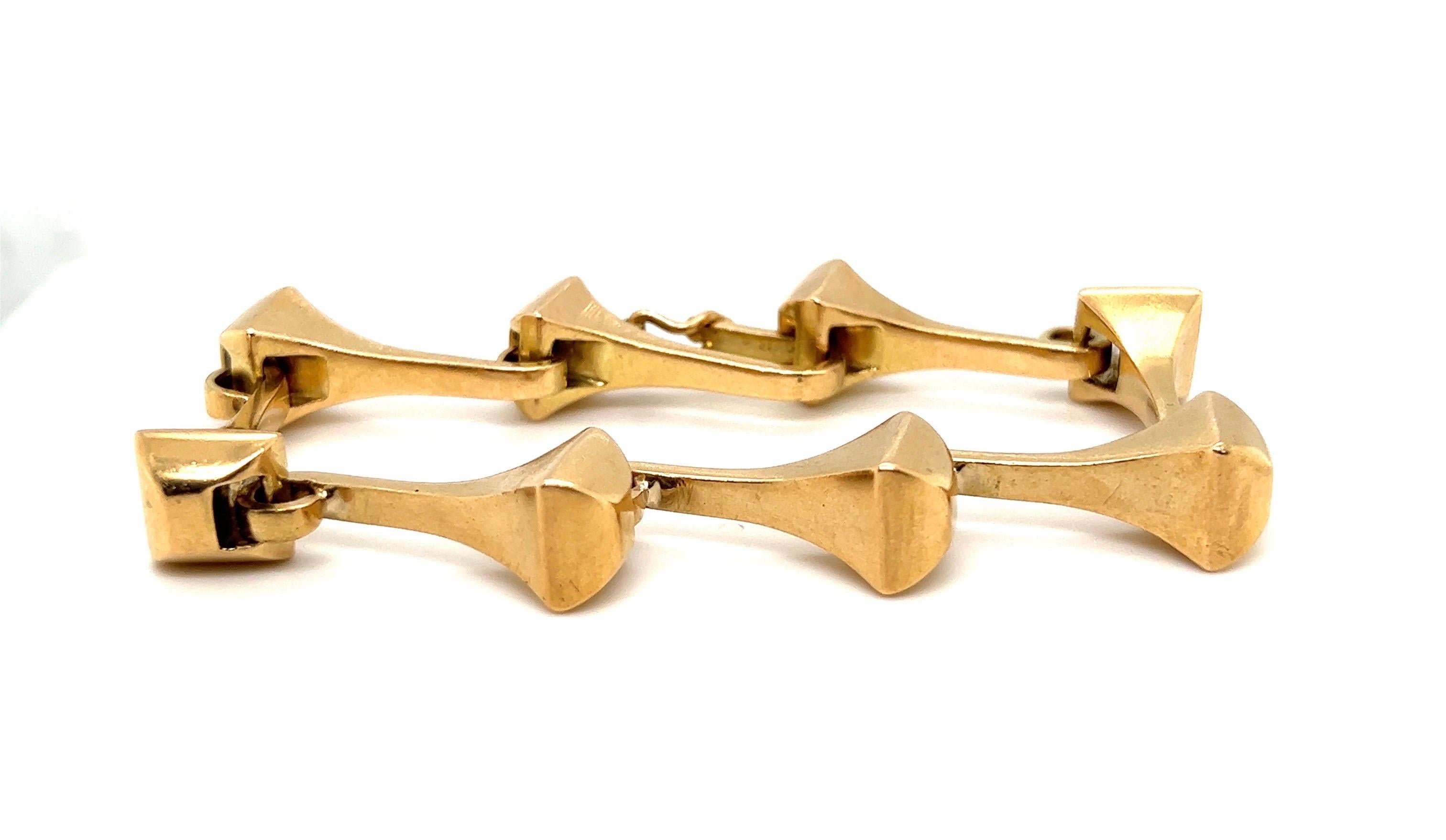 Striking 18 karat yellow gold horseshoe nail bracelet by Gucci, 1970s.
Crafted in 18 karat solid yellow gold and designed as a line of 8 interlocking stylized horseshoe nails. The bracelet closes with a locking clasp completed by a safety latch.