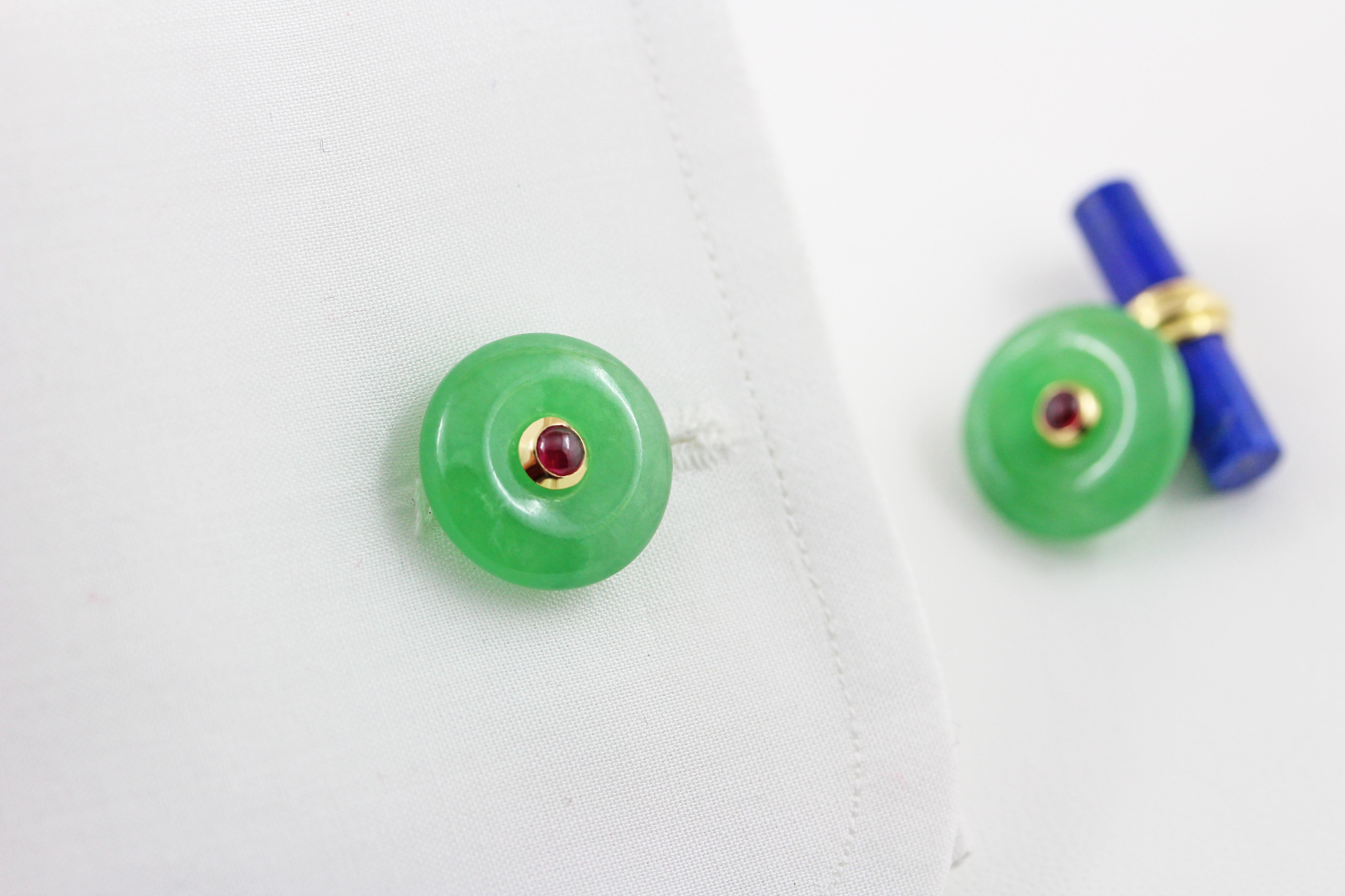These exquisite cufflinks feature a striking contrasting color combination produced by the vivid green of the front face in jade, shaped as a circle with a cabochon ruby adorning its center, and the dark blue of the lapis lazuli toggle, carved as a