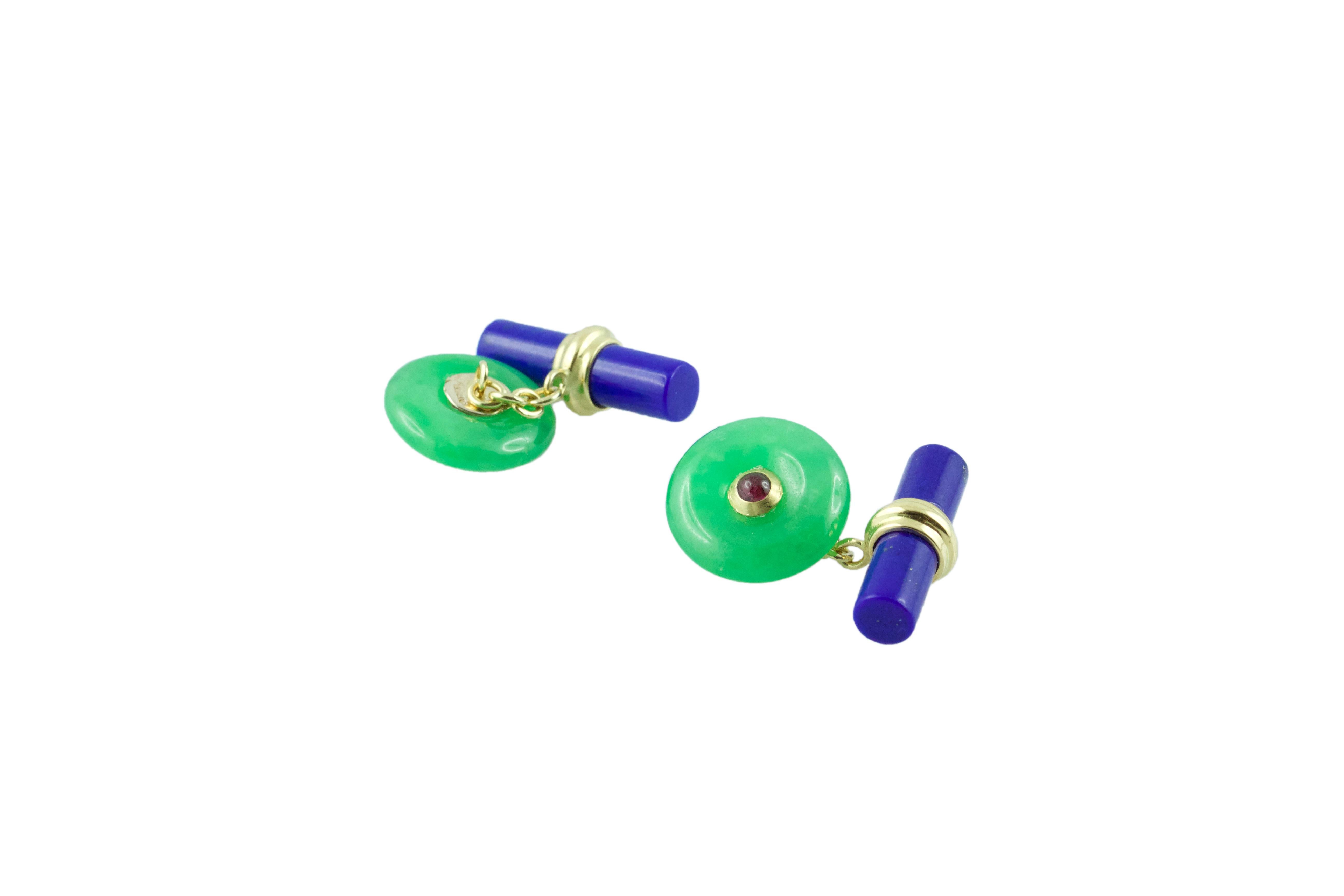 These exquisite cufflinks feature a striking contrasting color combination produced by the vivid green of the front face in jade, shaped as a circle with a cabochon ruby adorning its center, and the dark blue of the lapis lazuli toggle, carved as a