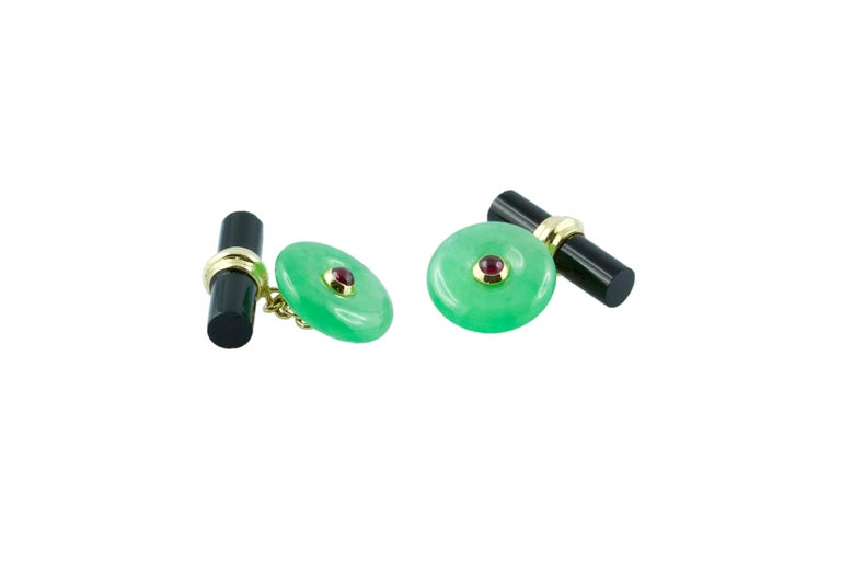 These exquisite cufflinks feature a striking contrasting color combination produced by the vivid green of the front face in jade, shaped as a circle with a cabochon ruby adorning its center, and the black of the onyx toggle, carved as a minimalist