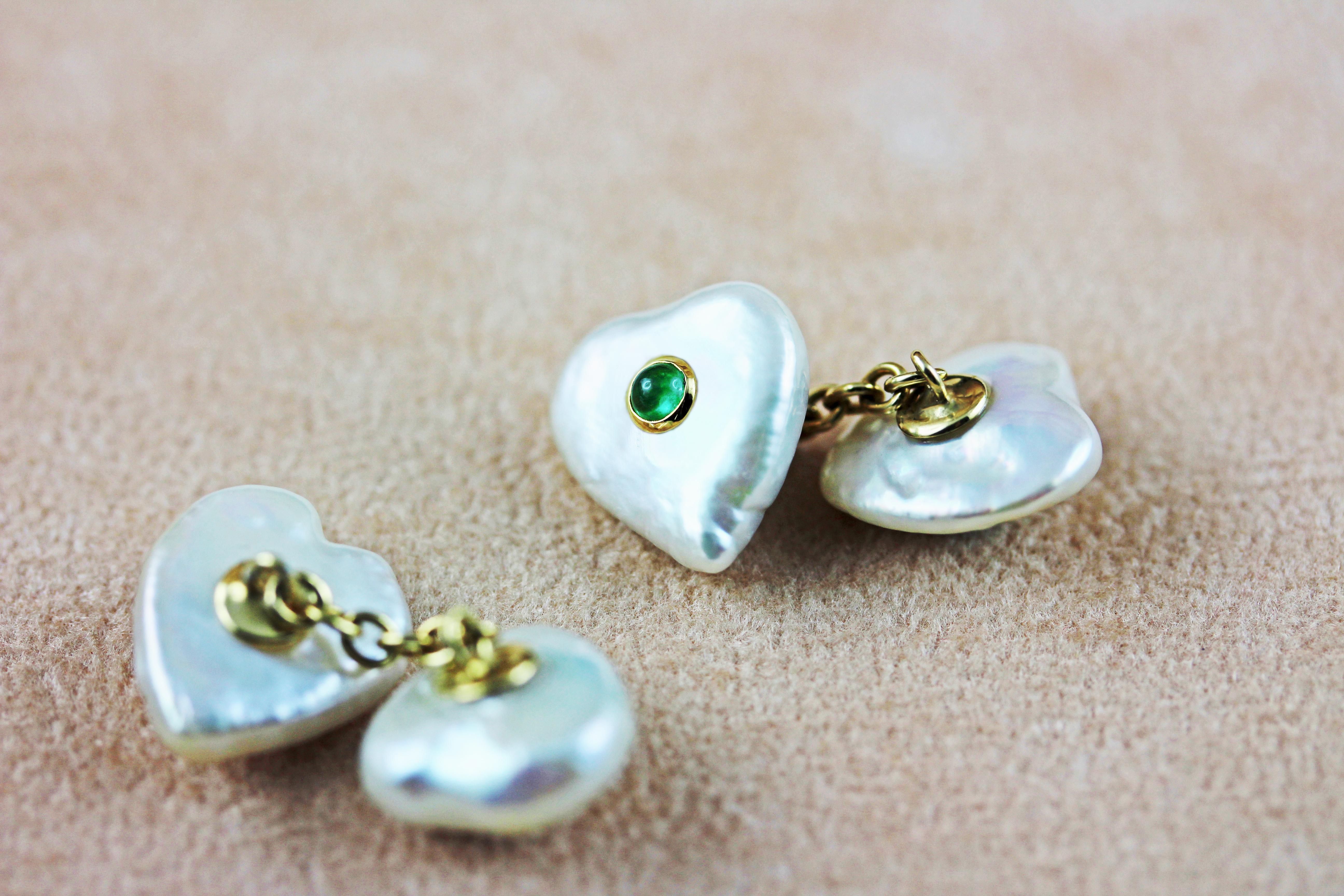 Shaped as hearts, the Keshi pearls that make both front face and toggle of these striking cufflinks are one-of-a-kind accents that make this piece charming and timeless. 
Each pearl is adorned in the center with one cabochon emerald stone mounted in