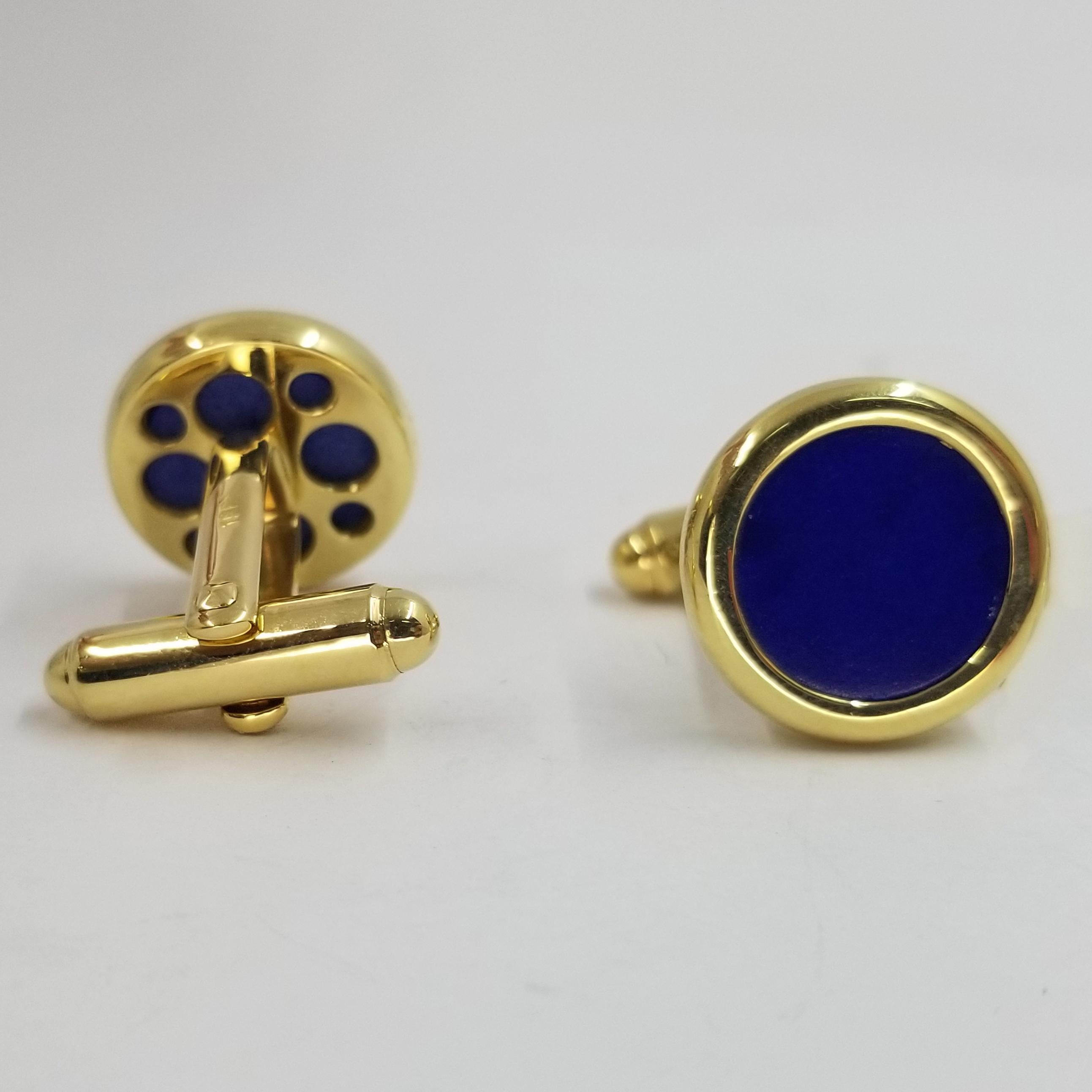 Set of 2 cufflinks crafted in 18 karat yellow gold (stamped). The fronts are polished bezels with flat circular Lapis Lazuli inlay. The backs are a hinged torpedo style for easy dressing.