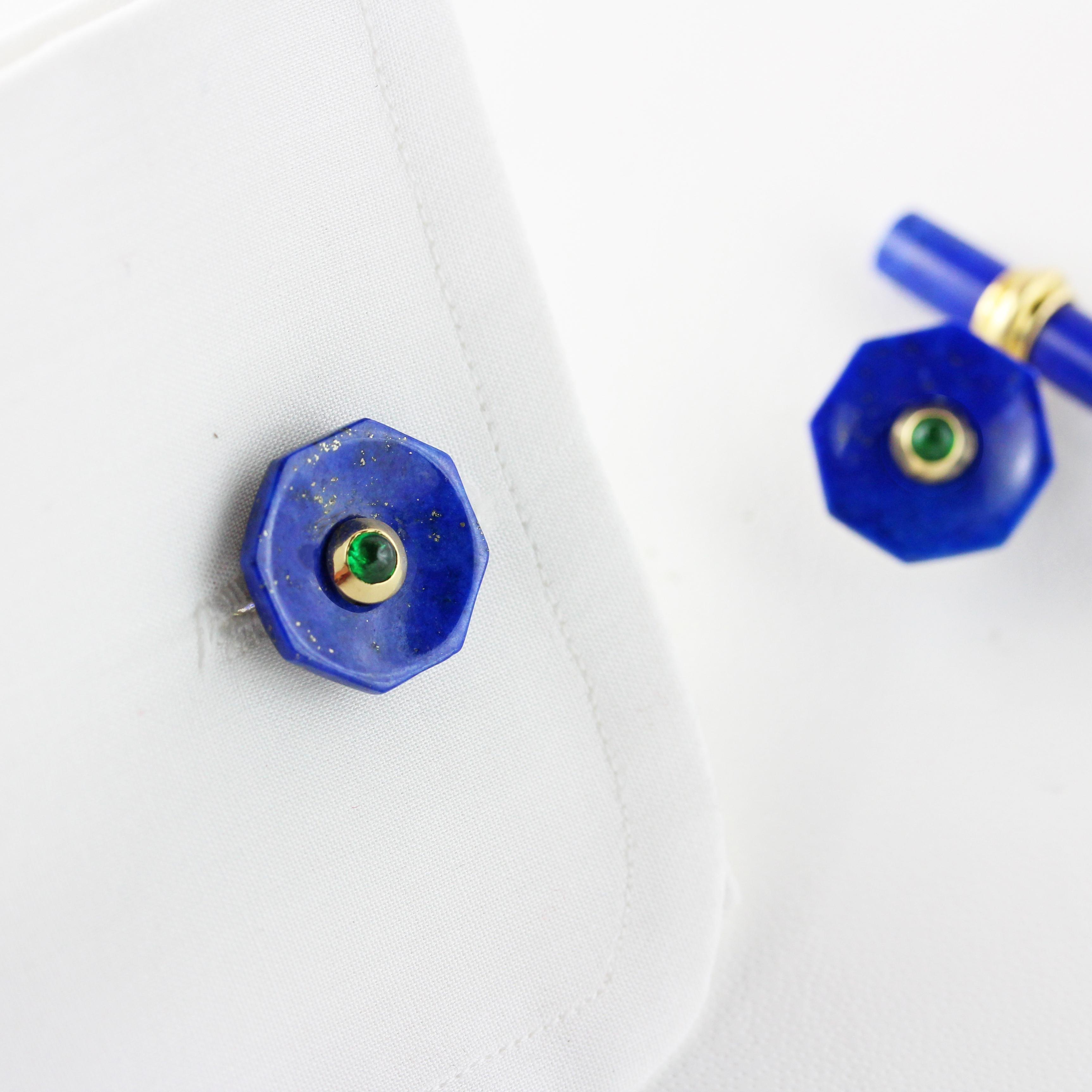 This elegant pair of cufflinks made in lapis lazuli  features a cylindrical toggle and a front face shaped as an octagon with a convex, multifaceted surface and a central ornament made of a emerald cabochon. 
The post linking front face and toggle
