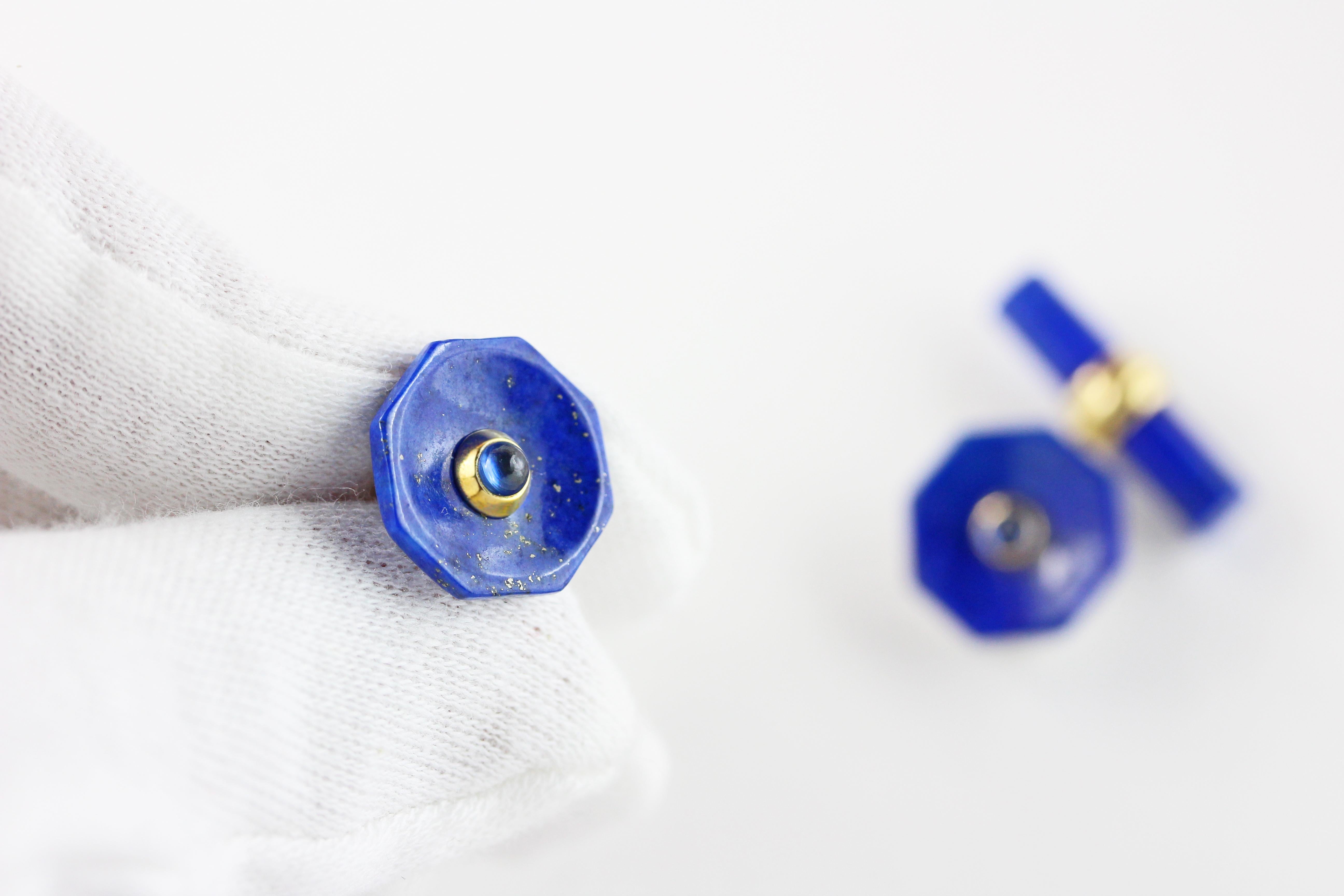 This elegant pair of cufflinks made in lapis lazuli  features a cylindrical toggle and a front face shaped as an octagon with a convex, multifaceted surface and a central ornament made of a sapphire cabochon. 
The post linking front face and toggle