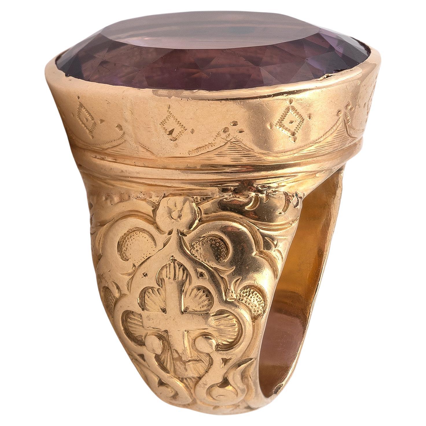 Anillo de oro amarillo de 18 quilates engastado en bisel con una gran amatista ovalada, el hombro decorado con cruces cinceladas
Talla 7
Peso 15,7 gr