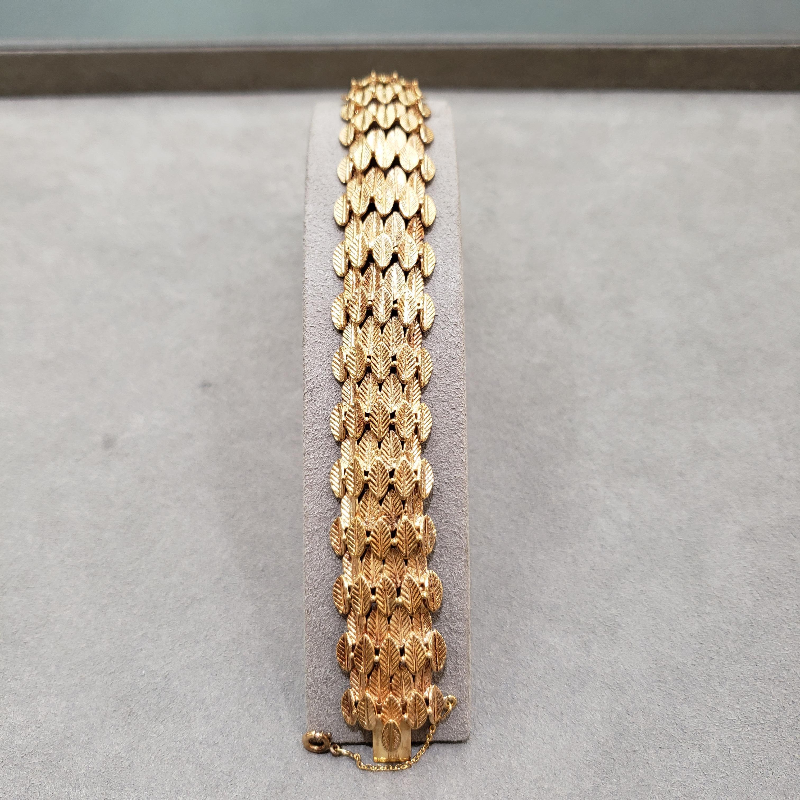 Features nine rows of golden leaves made in 18 karat yellow gold. Approximately 7 inches in length; 44.56 grams.