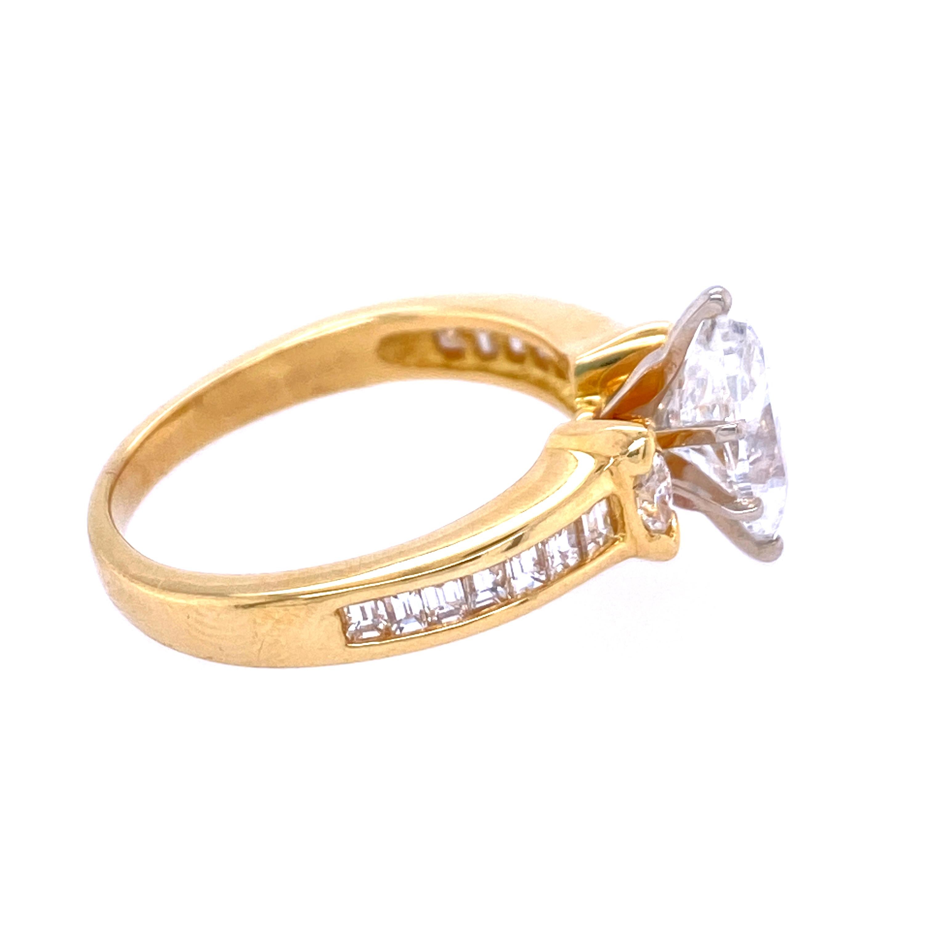 One 18 karat yellow gold (stamped 18K) engagement ring prong set with one marquise cut diamond, approximately  1.33 carat total weight with I color and I1 clarity measuring ....
the diamond is flanked by two marquise cut diamonds, 4x2.5mm each,