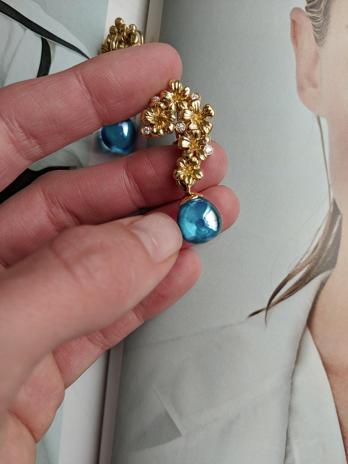 Ces boucles d'oreilles cocktail Plum Blossom présentent des gouttes amovibles en topaze naturelle bleue cabochon et sont incrustées de 10 diamants ronds. Elles sont en or jaune 18 carats et appartiennent à une collection qui a été présentée dans la