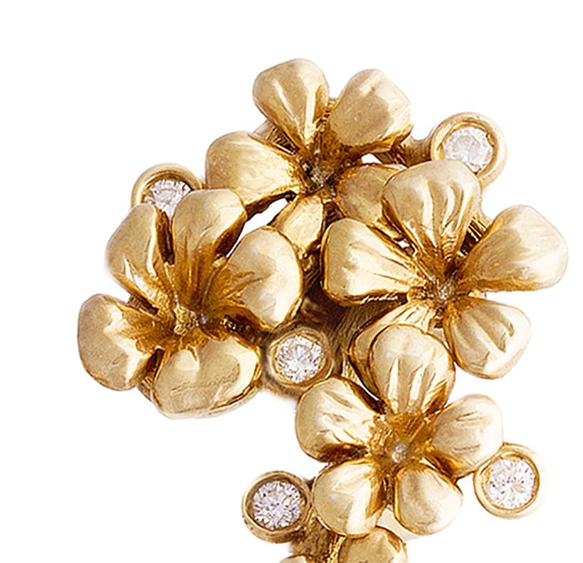 This Plum Blossom brooch features a modern style design and is crafted from 18 karat yellow gold. It is adorned with 5 round diamonds and a removable drop of natural emerald (around 3 carats) that can be taken off. The collection has been featured