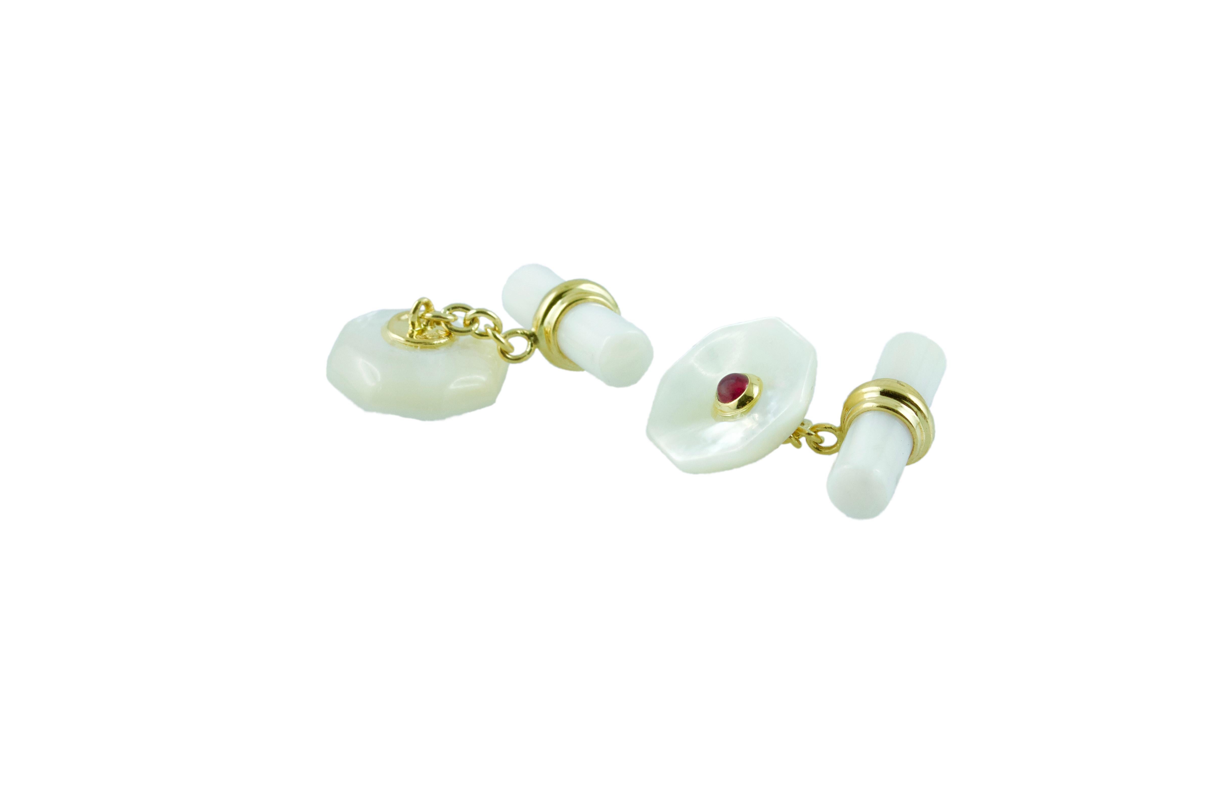This elegant pair of cufflinks made in Mother of Pearl features a cylindrical toggle and a front face shaped as an octagon with a convex, multifaceted surface and a central ornament made of a cabochon ruby. The post linking front face and toggle and