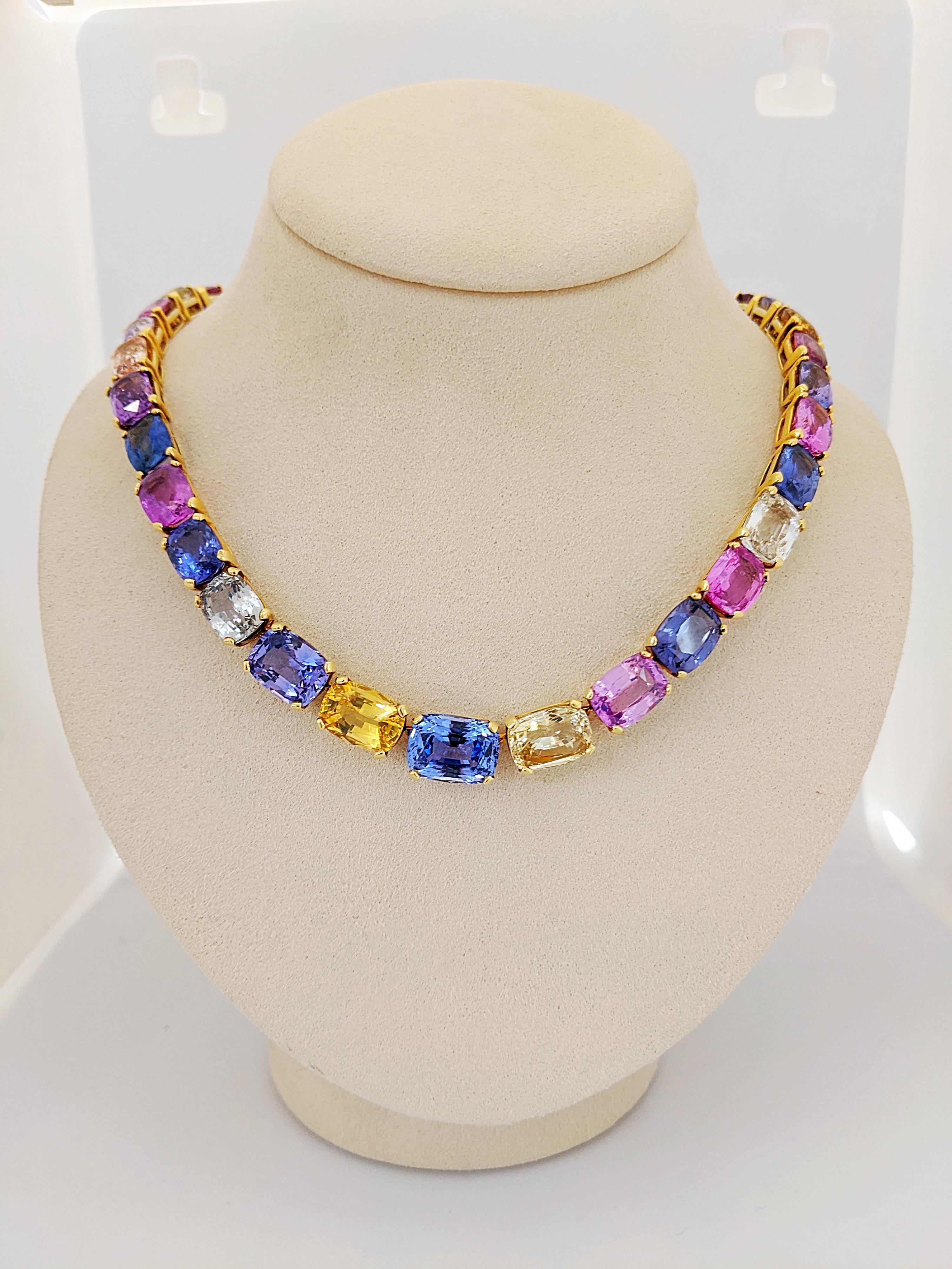 This show- stopping sapphire necklace is comprised of an array of natural colored sapphires including blues, yellow, pinks and purples, set in 18kt yellow gold. The brilliantly colored cushion cut sapphires graduate in size and lay elegantly on ones