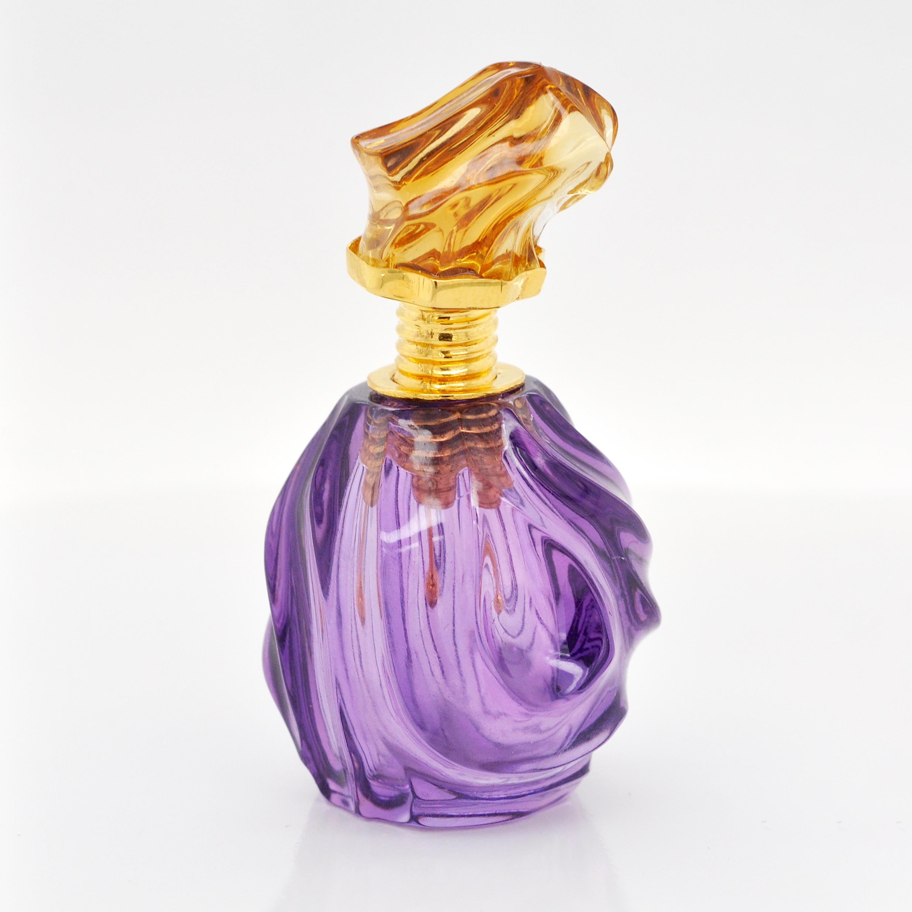 Voici un flacon de parfum étonnant, où la simplicité s'allie à la sophistication pour une expérience olfactive inoubliable.

Fabriquée en améthyste, la base présente des vagues abstraites sculptées avec précision, créant un motif hypnotique qui