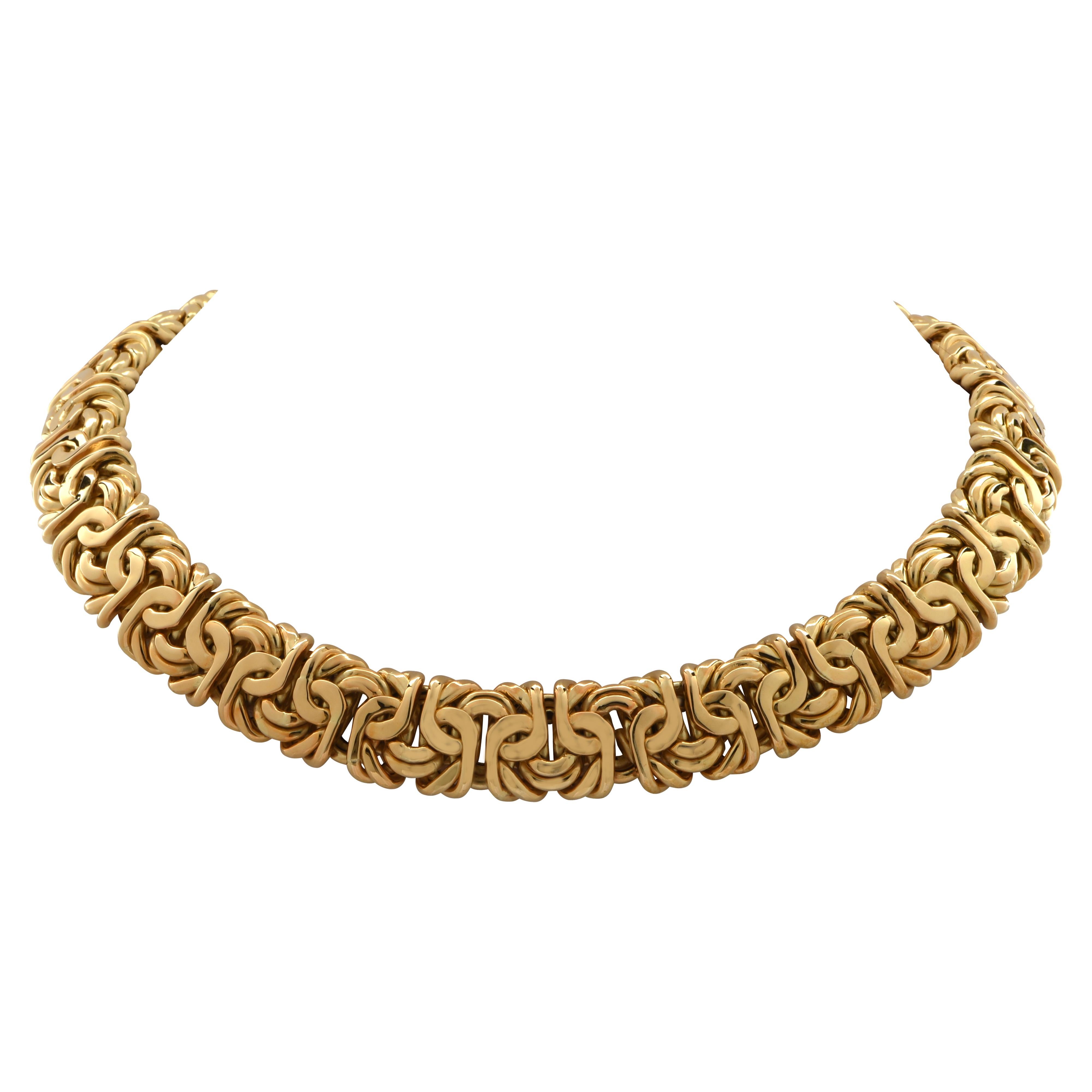 Striking necklace crafted in 18 Karat Yellow Gold. This bold statement piece measures 17 mm in width and 17 inches in length, and weighs 144.3 grams. The links twirl and interweave as they wrap luxuriously around your neck. This necklace closes with