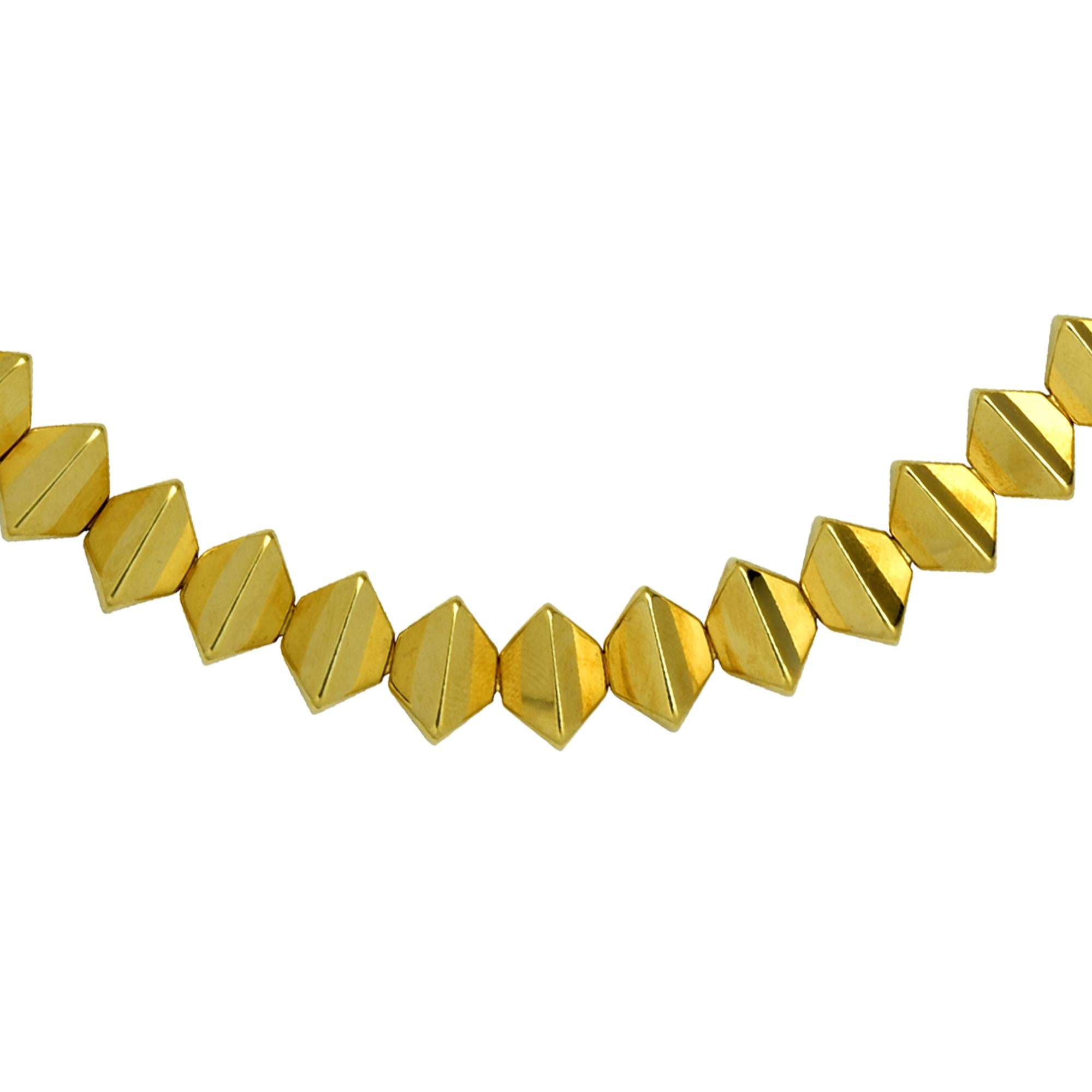 Gorgeous necklace crafted in 18 karat yellow gold featuring geometric shapes flowing together to create the illusion of a seamless stream of triangular pyramids. This eye catching necklace measures 16.5 inches and weighs 44.16 grams.

