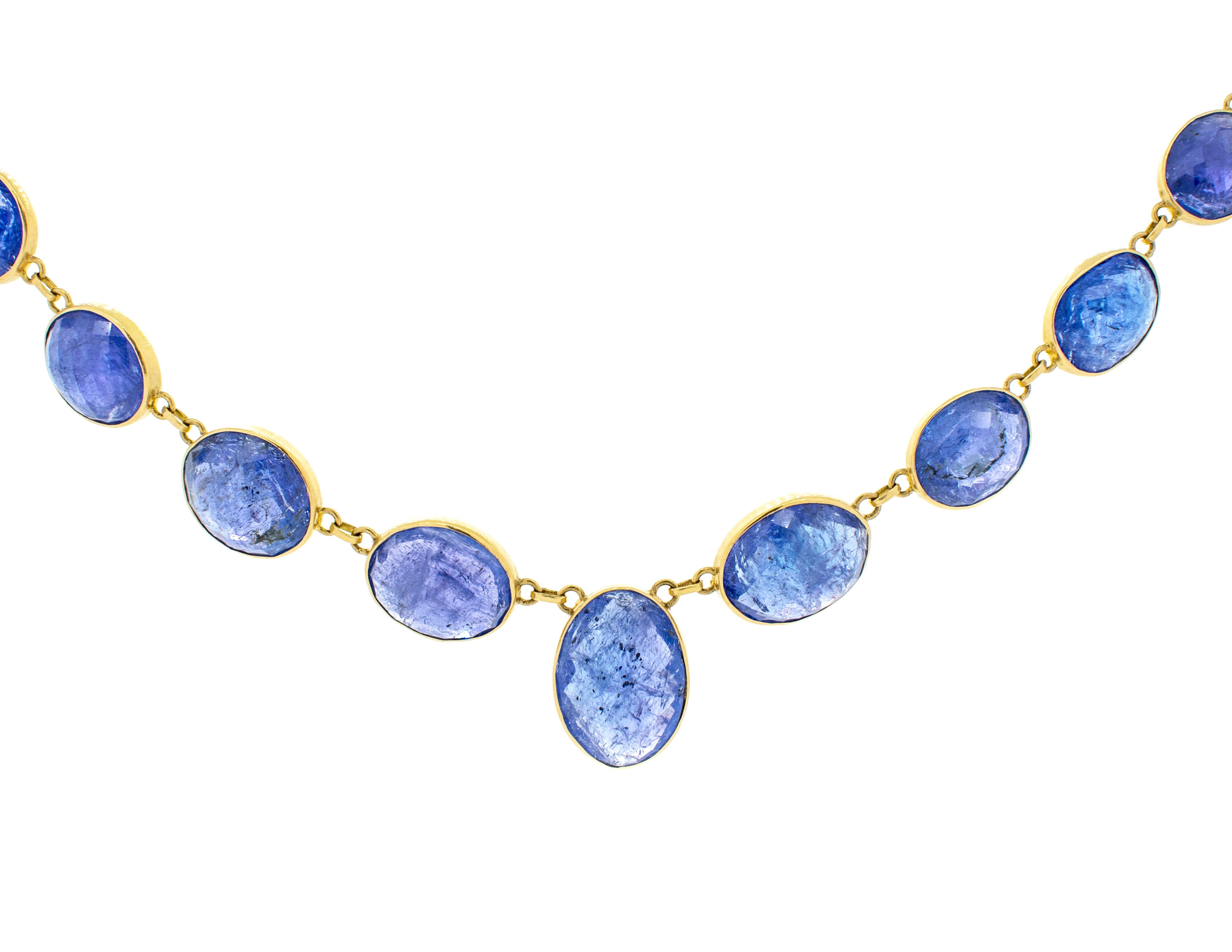 Collier en or jaune 18 carats avec 15 pierres de Tanzanite, de taille graduée, montées dans une monture biseautée faite à la main. Chaque tanzanite est d'un bleu violacé profond, et sa couleur et sa clarté sont bien assorties. Le poids total des 15