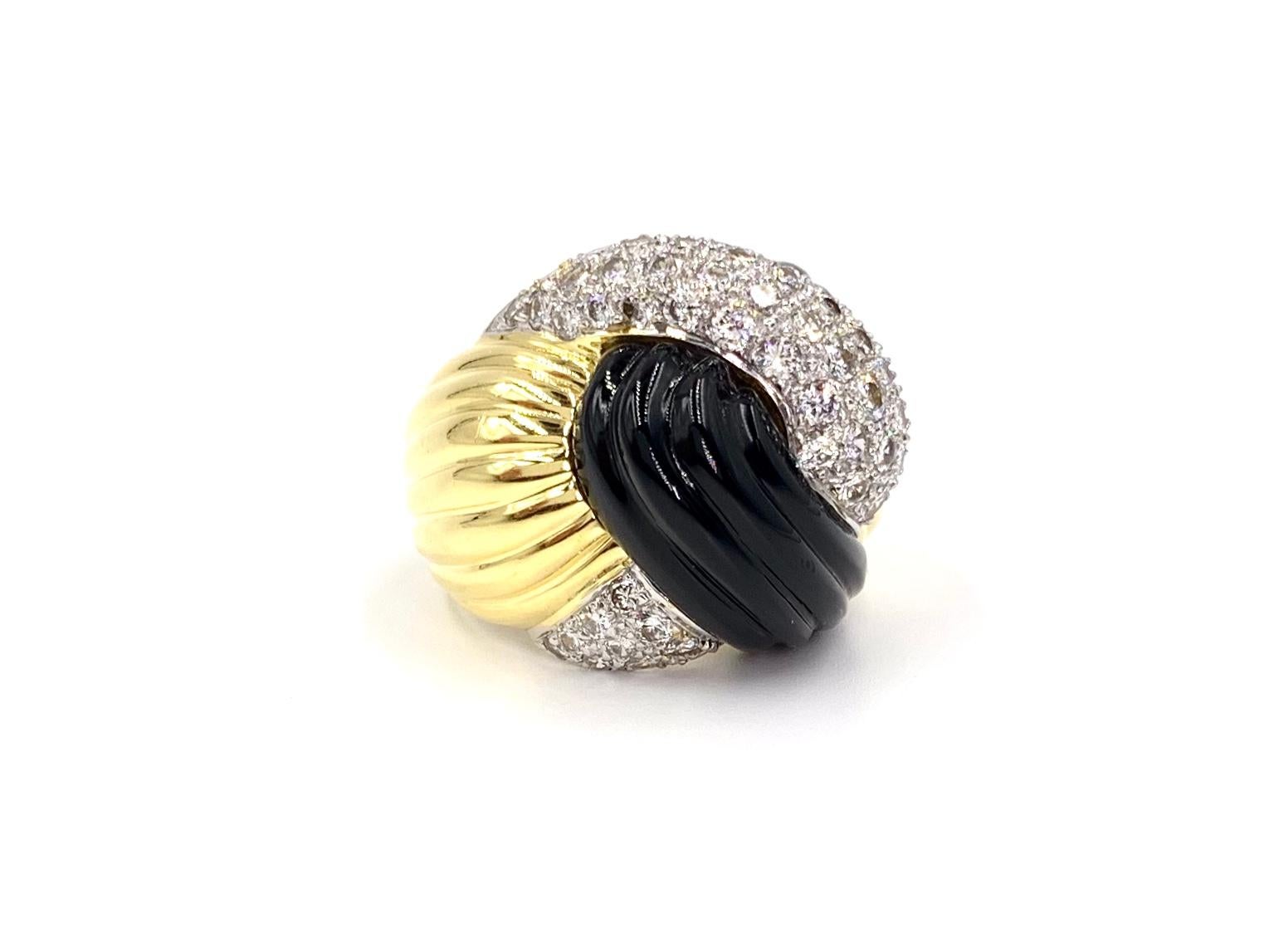 A well made and substantial 18 karat yellow gold modern ring featuring carved smooth black onyx and 1.72 carats of white round brilliant pavé set diamonds. Diamonds are approximately F-G color, VS2 clarity (eye clean) and are set in white gold for