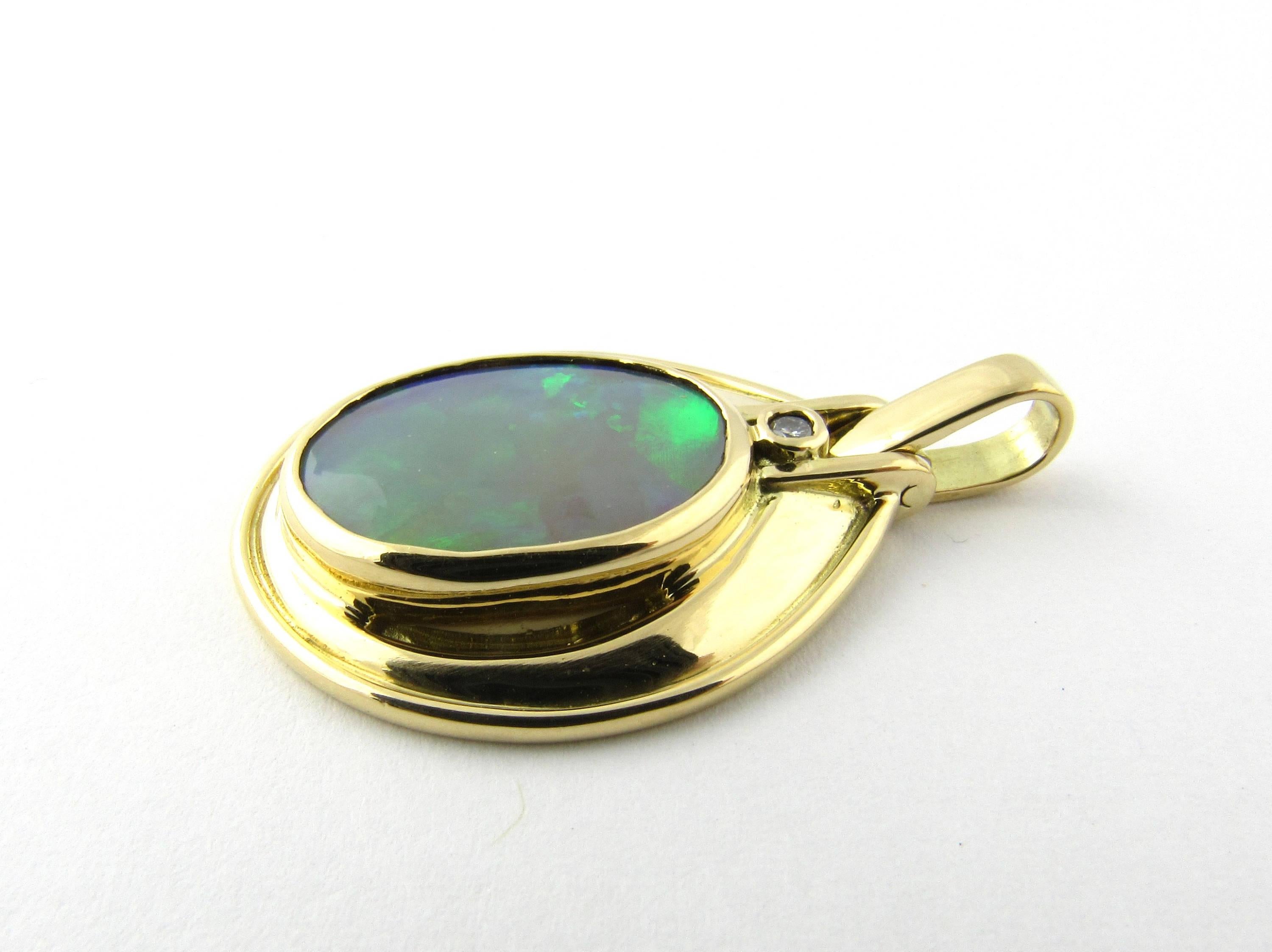 Vintage 18 Karat Yellow Gold Opal and Diamond Pendant- 
This stunning pendant features one oval opal (16 mm x 13 mm) framed in polished 18K gold and accented with one round brilliant cut diamond. 
Approximate total diamond weight: .03 ct. 
Diamond