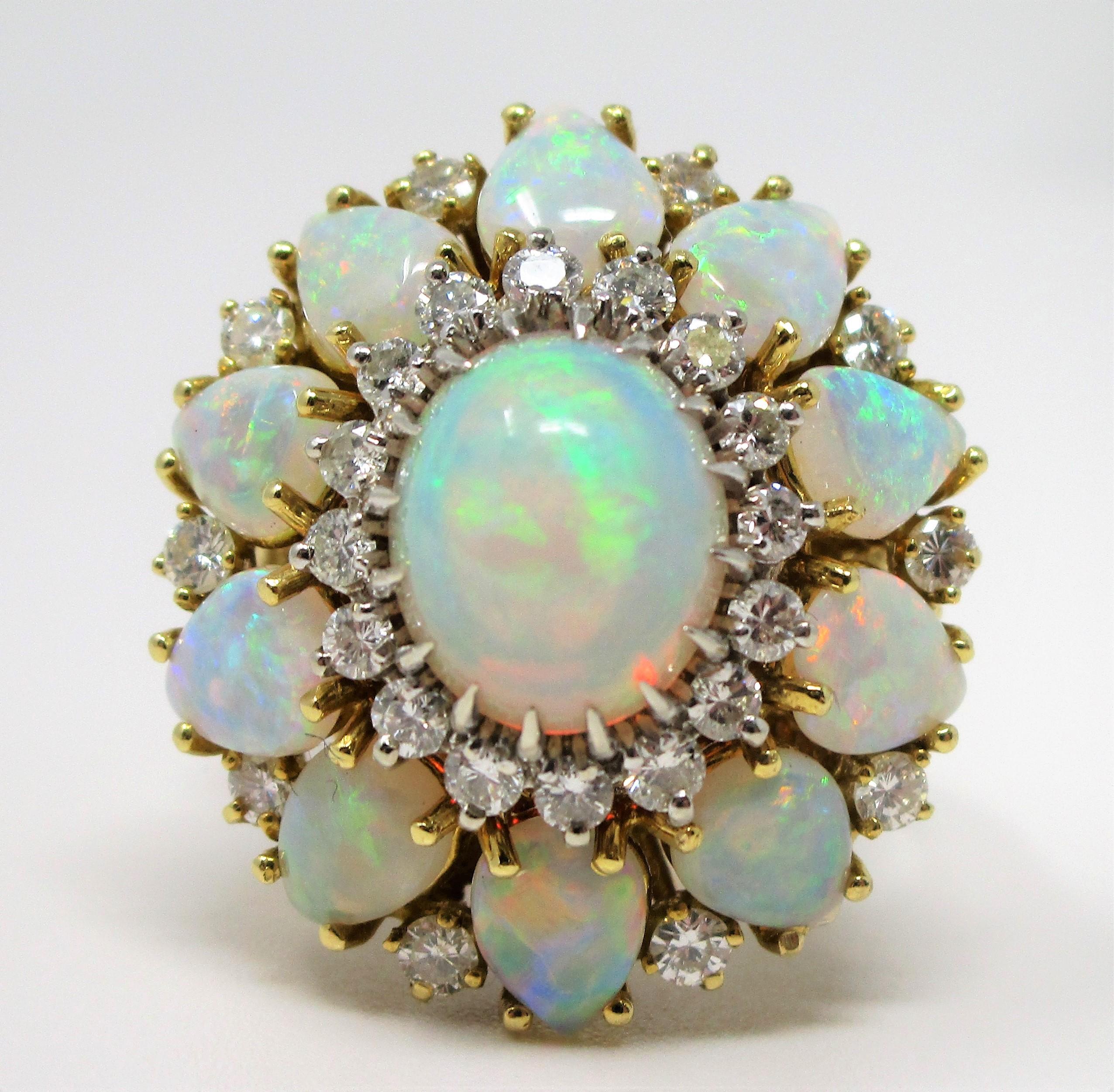 Stunning opals clustered with diamonds in 18 karat yellow gold.  Oval center opal with diamond halo is surrounded by pear opals and more diamonds! 
Opals have beautiful fire.  This ring is a size 6.