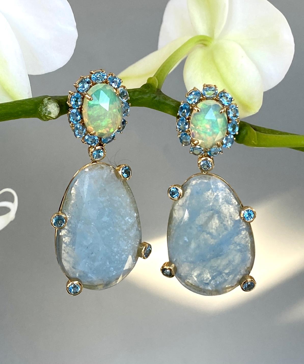 Exquisite drop dangle earrings of opals, blue topaz, and rose cut aquamarines, handcrafted in 18 karat yellow gold.

These one-of-a-kind earrings are in subtle shades of baby blue aquamarines and shimmering greenish-blue opals, with vibrant blue