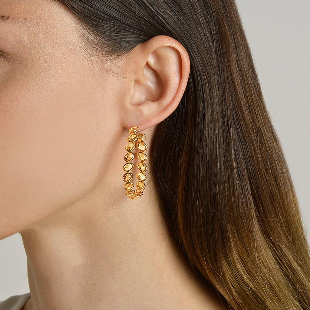 18kt yellow gold Ombré hoop earrings with bezel set multishade oval orange sapphires at 11 o'clock® and signature Brillante® motif, grande.

Reimagined from summers spent at the Tuscan shore, the Ombré collection highlights the diverse hues and