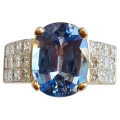 18 Karat Yellow Gold Oval 4.45 Carat Blue Sapphire 24 Princess Cut Invisible Set