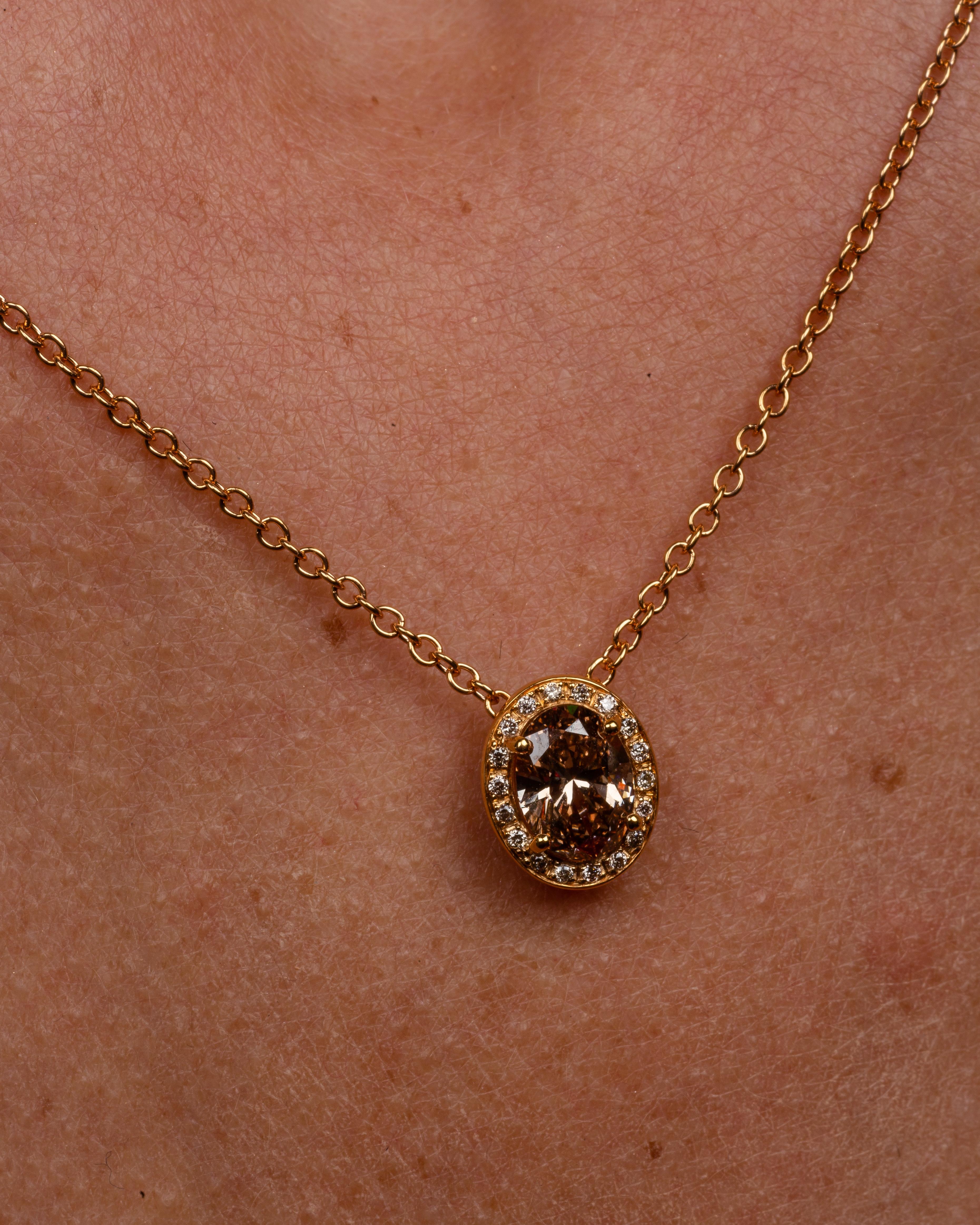 Dieser elegante Anhänger aus 18 Karat Gelbgold ist aus unserer Divine Collection. Er besteht aus einem ovalen braunen Diamanten von insgesamt 1,01 Karat, verziert mit runden farblosen Diamanten von insgesamt 0,07 Karat und runden braunen Diamanten