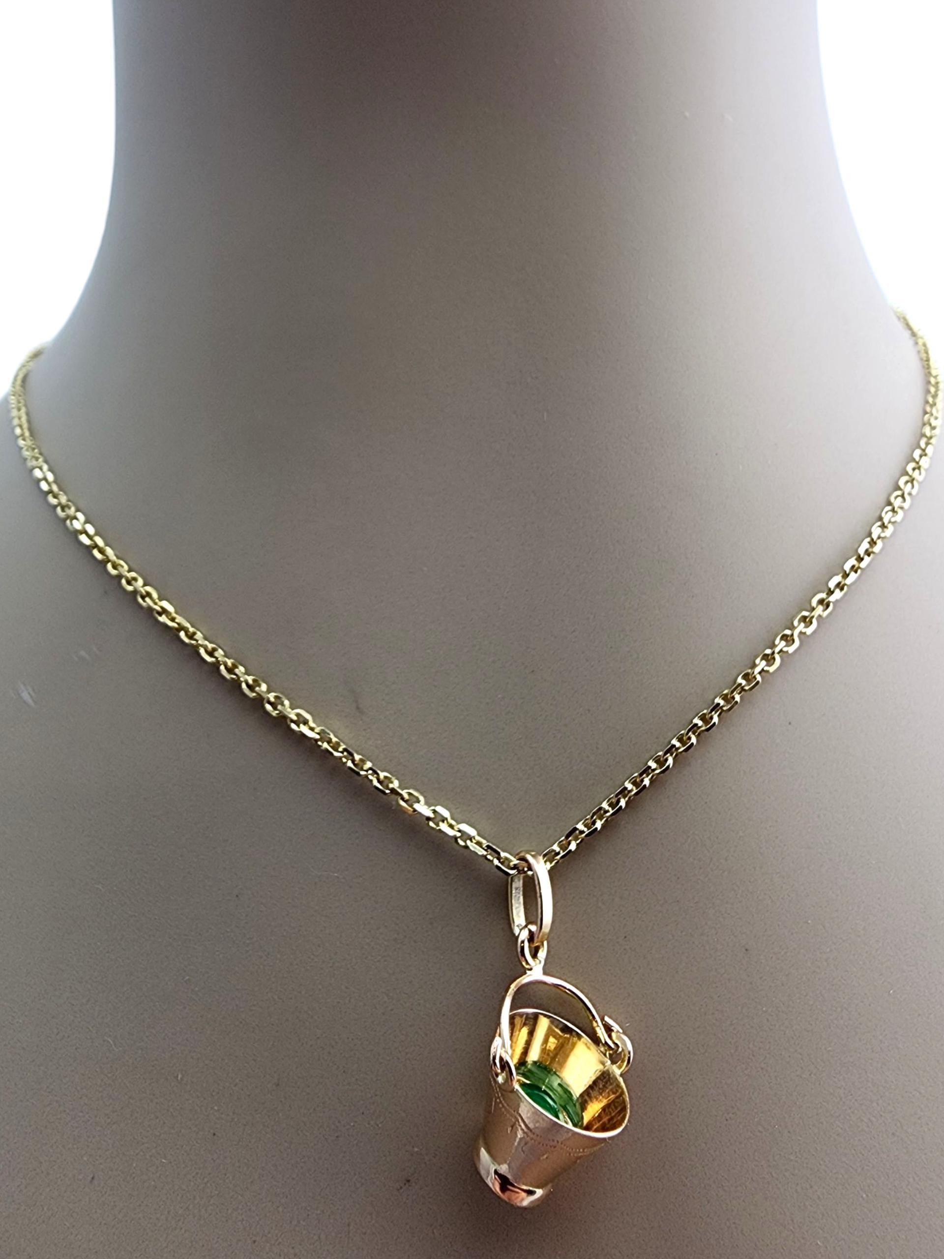 Charm con maniglia mobile in oro giallo 18 carati - Pail

Questo ciondolo in oro giallo 18 carati presenta un design unico a forma di secchio ornato da una vivida pietra verde, che unisce creatività ed eleganza. La finitura lucida e i dettagli