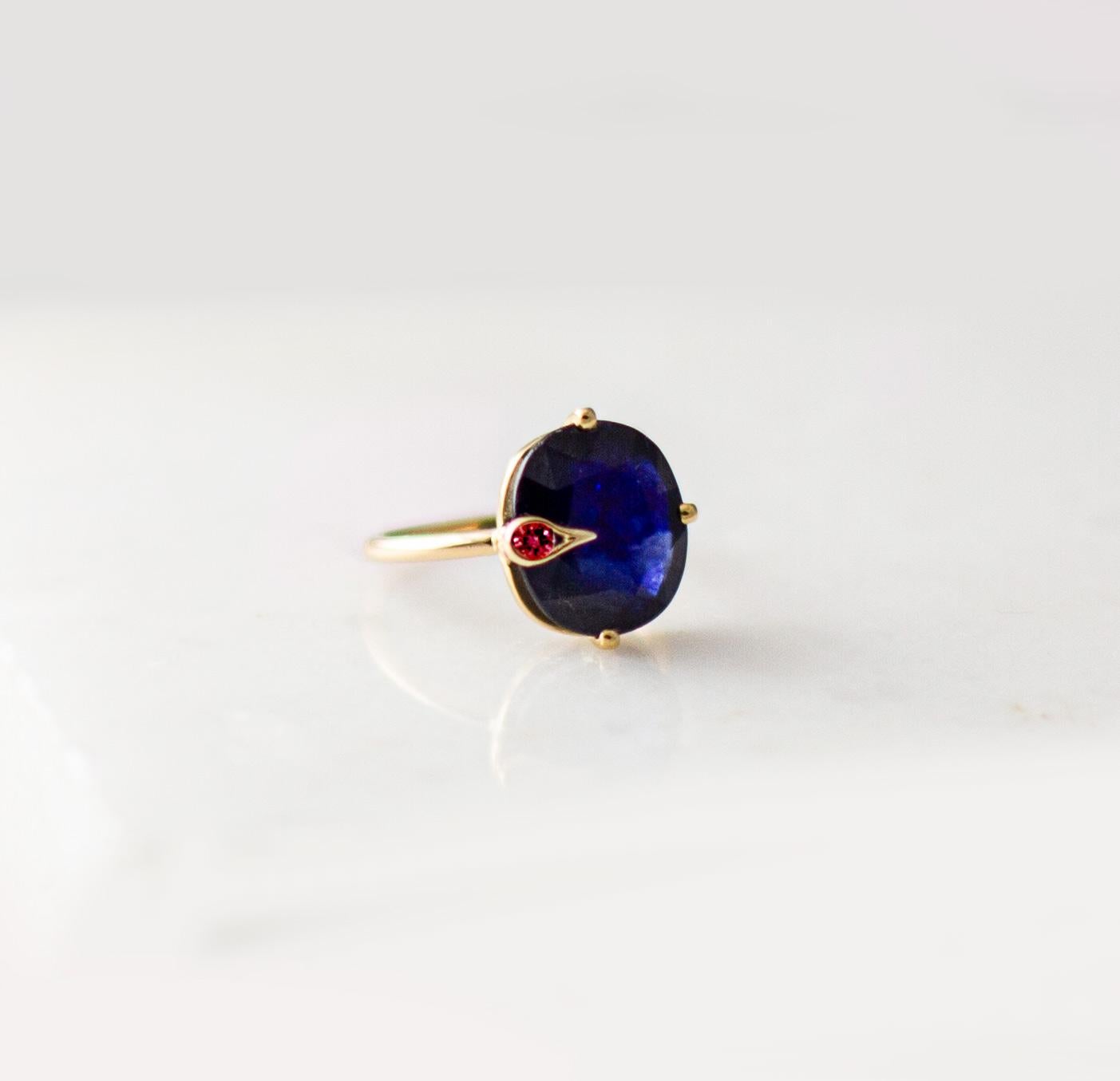 This contemporary engagement Peacock ring is in 18 karat yellow gold with unheated natural cushion cut blue sapphire, 2,55 carats, 0,35x0,3 inches / 9x7,8 mm, and round ruby. The ring is easy to wear, and the gem catches eye's attention. 
The