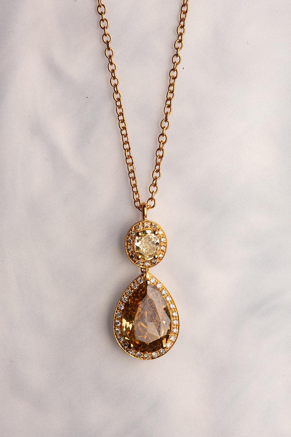 This 18K yellow gold elegant pendant is from our Divine Collection. It is made of a pear shape brown diamond in total of 2.39 Carat and oval shape yellow diamond in total of 0.42 Carat. Both diamonds are decorated by round colourless diamonds in