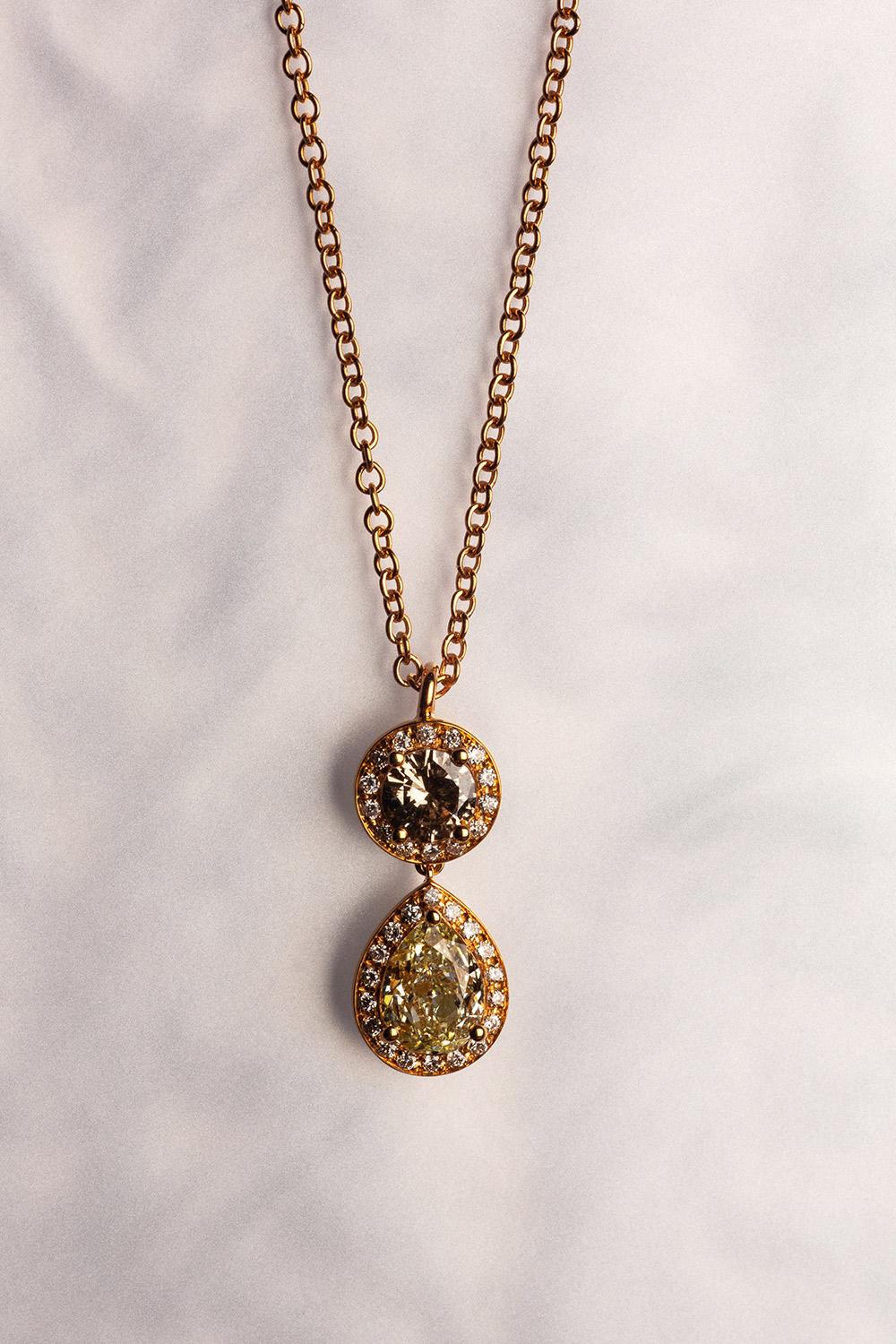 This 18K yellow gold elegant pendant is from our Divine Collection. It is made of a round brown diamond in total of 0.38 Carat and pear shape yellow diamond in total of 1.02 Carat. Both diamonds are decorated by round colourless diamonds in total of