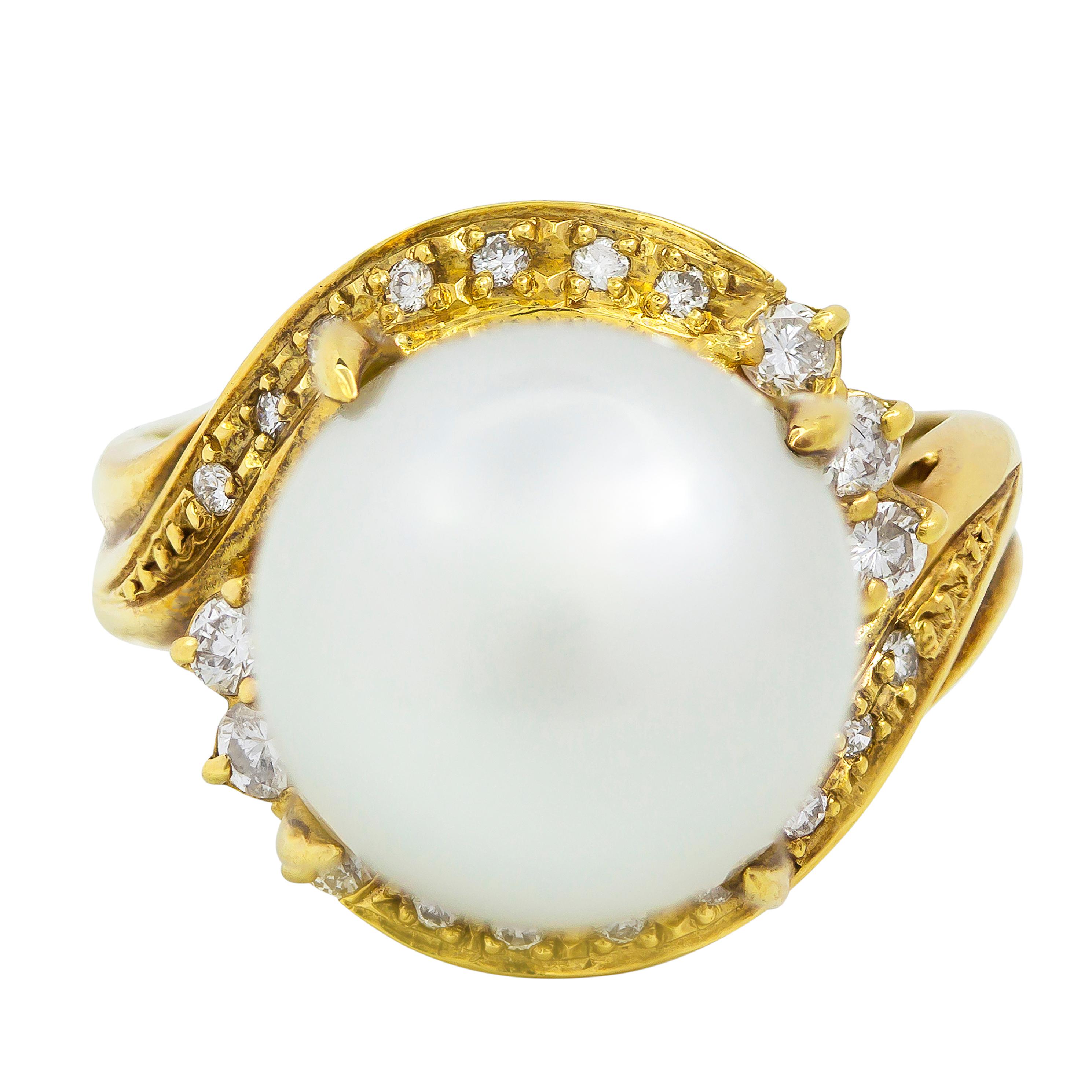 An antique and unique style engagement ring showcasing a single 11.60mm pearl center stone elegantly enclosed in a bypass design accented with sparkling round diamonds. Diamonds weigh approximately 0.09 carats total. Made with 18k yellow gold. Size