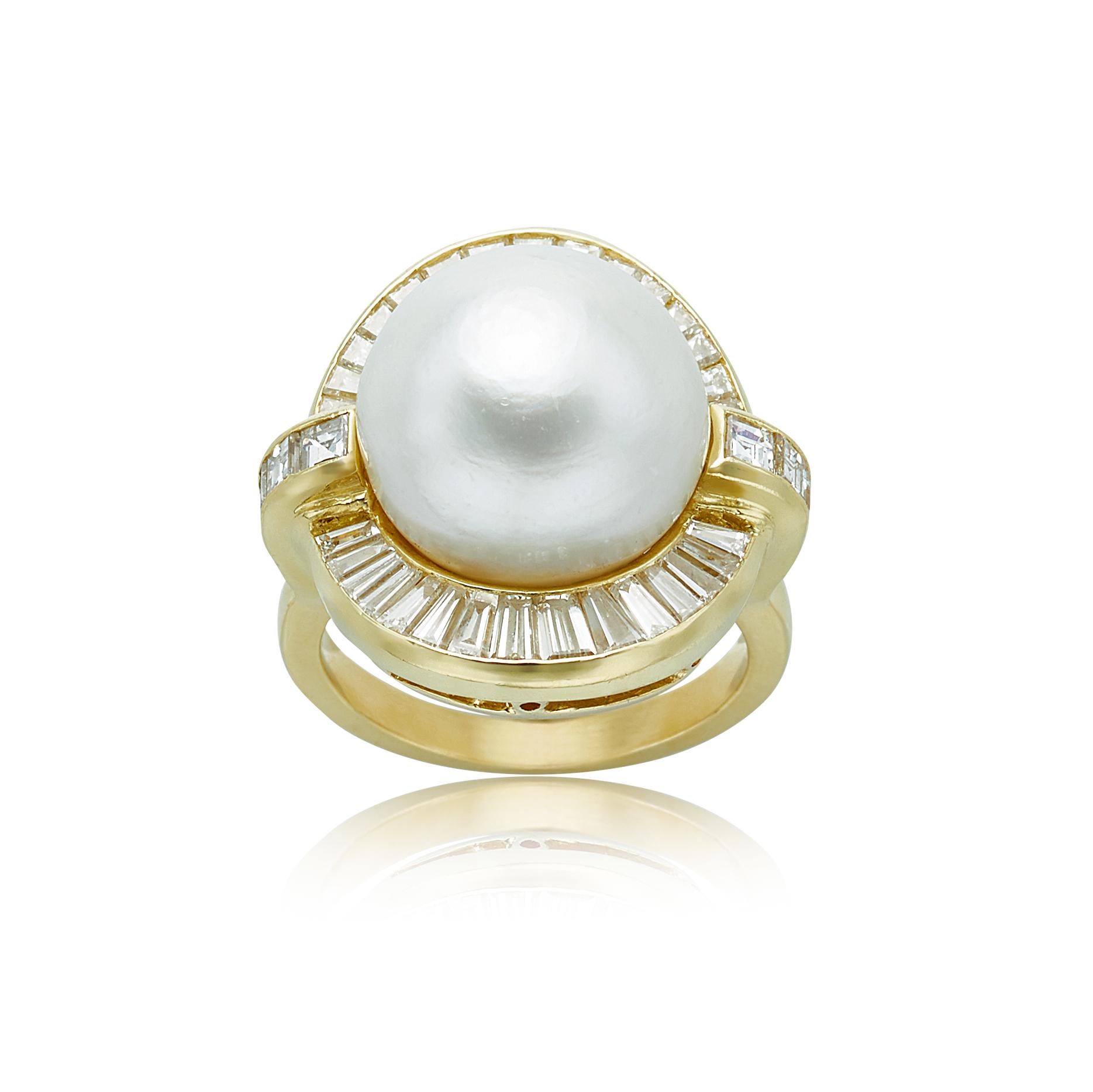 This 18k yellow gold ring features a pearl measuring at 13.5mm surrounded by 30 taper baguette cut diamonds, weighing 1.00 carats with G-H color and VS clarity. The ring is also paired with 10 square baguette cut diamonds, weighing 1.00 carats with