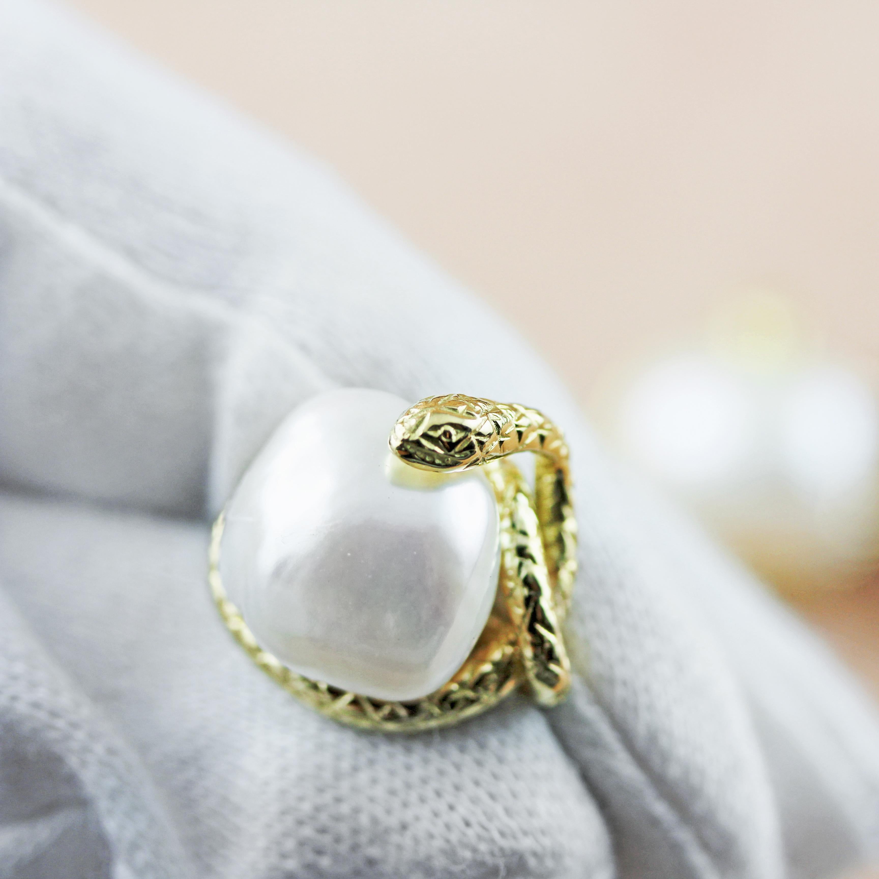 This magnificent pair of cufflinks features a baroque pearl gracing the front face, mounted on an 18 karat yellow gold piece shaped as a snake coiled all around the pearl. In gold is also the post that wraps around the cylindrical shape of the