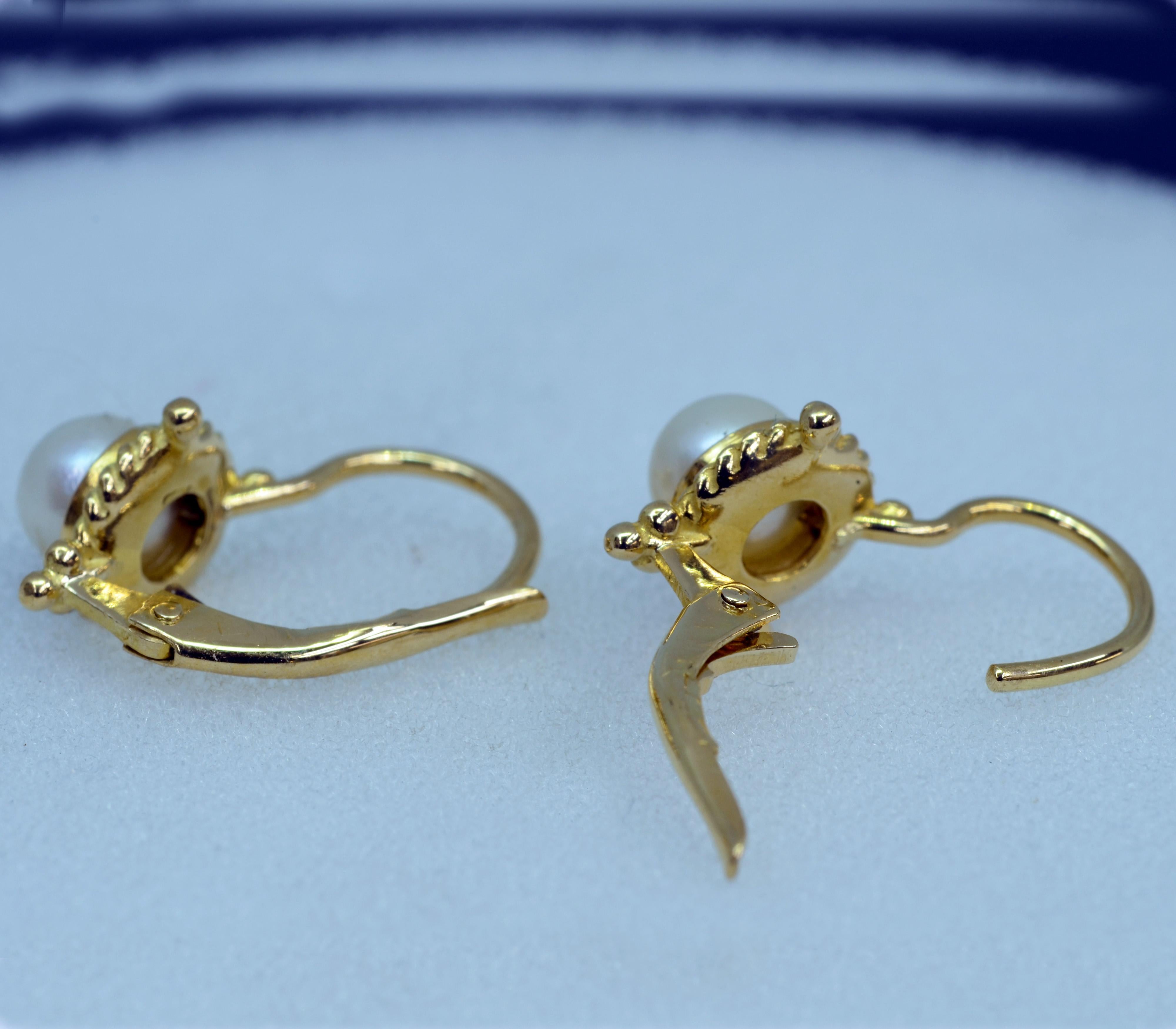 Very sweet pair of 18 Karat Yellow gold drop lever-back earrings. These are set with a pair of 5mm. round white cultured Pearls . They are accented with tiny gold beads. They are 8mm. in circumference.